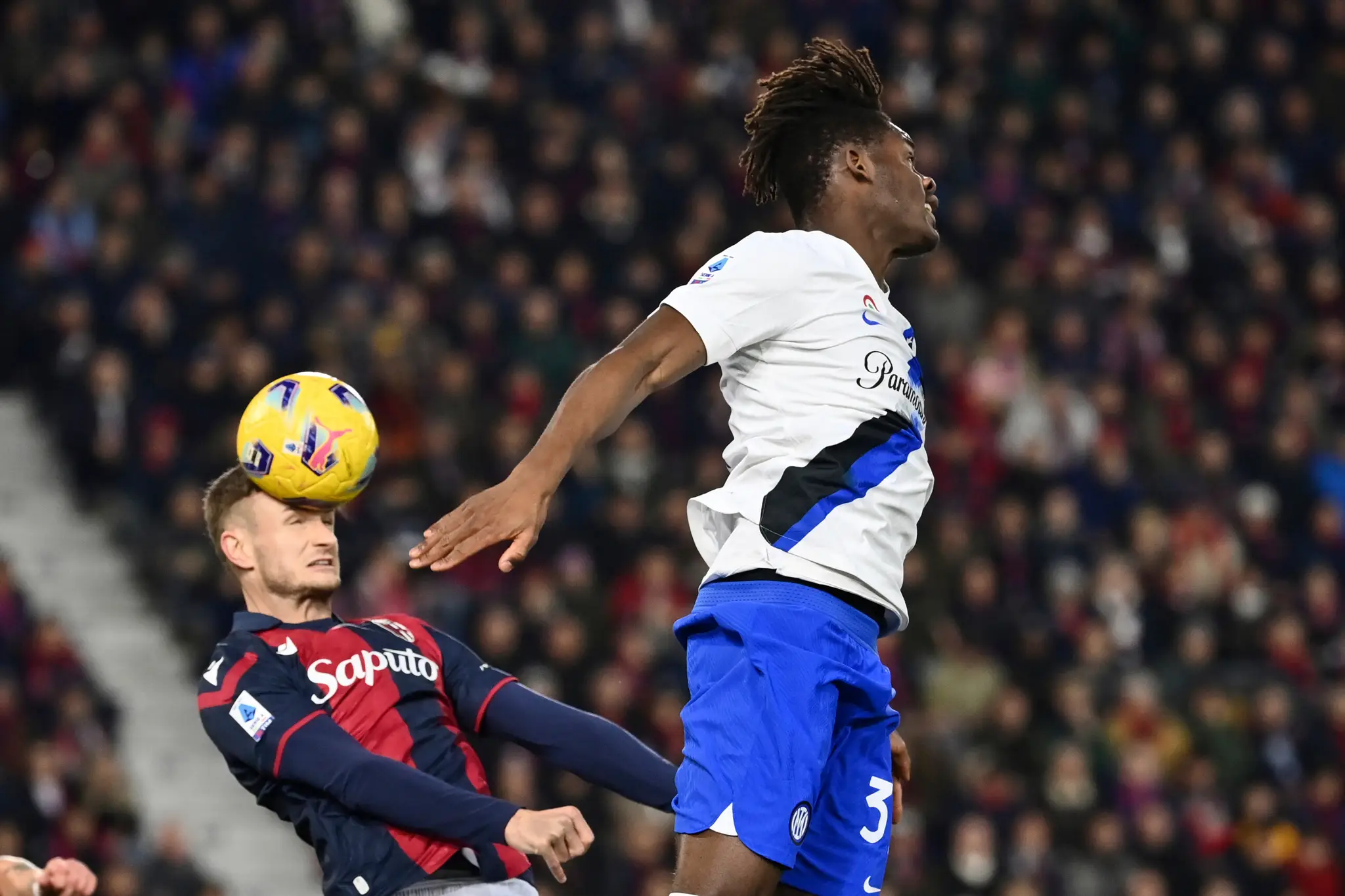 Futbalista Interu Miláno Yann Aurel Bisseck (vpravo) a hráč Bologne Stefan Posch bojujú o loptu.