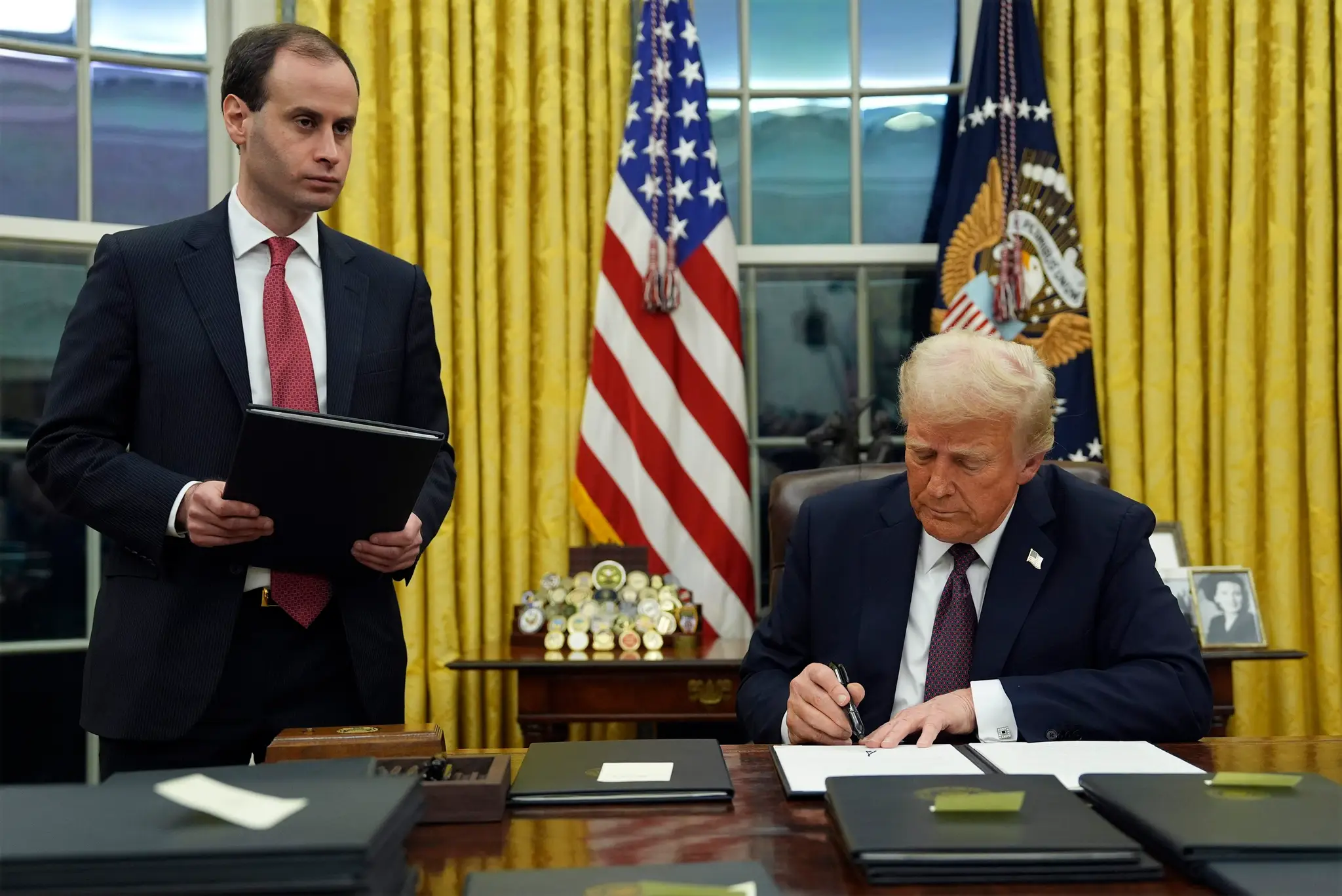 Na snímke Donald Trump podpisuje výkonný príkaz na vytvorenie Oddelenia vládnej efektívnosti.