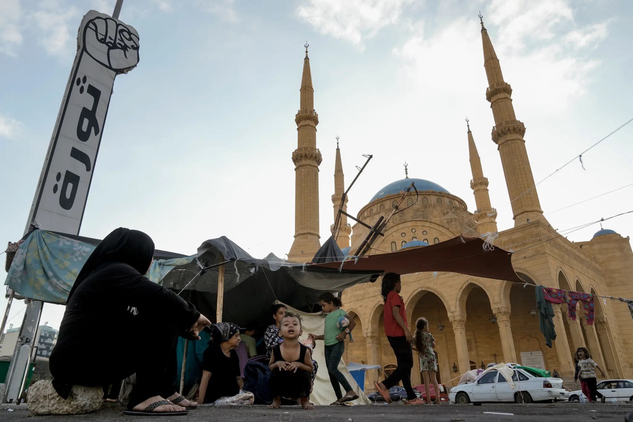Libanonská rodina, ktorá ušla pri izraelských leteckých útokoch, sedí v provizórnom stane pred mešitou Mohammada al-Amina v Bejrúte.