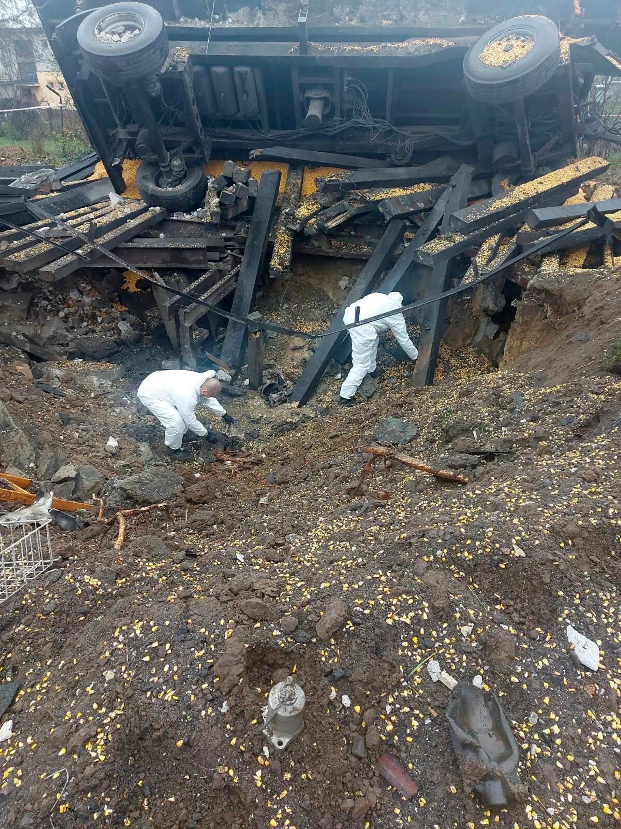 Na policajnej snímke experti vyšetrujú na mieste dopadu rakety v poľskej obci Przewodów, ktorá leží len asi šesť kilometrov od ukrajinských hraníc. 