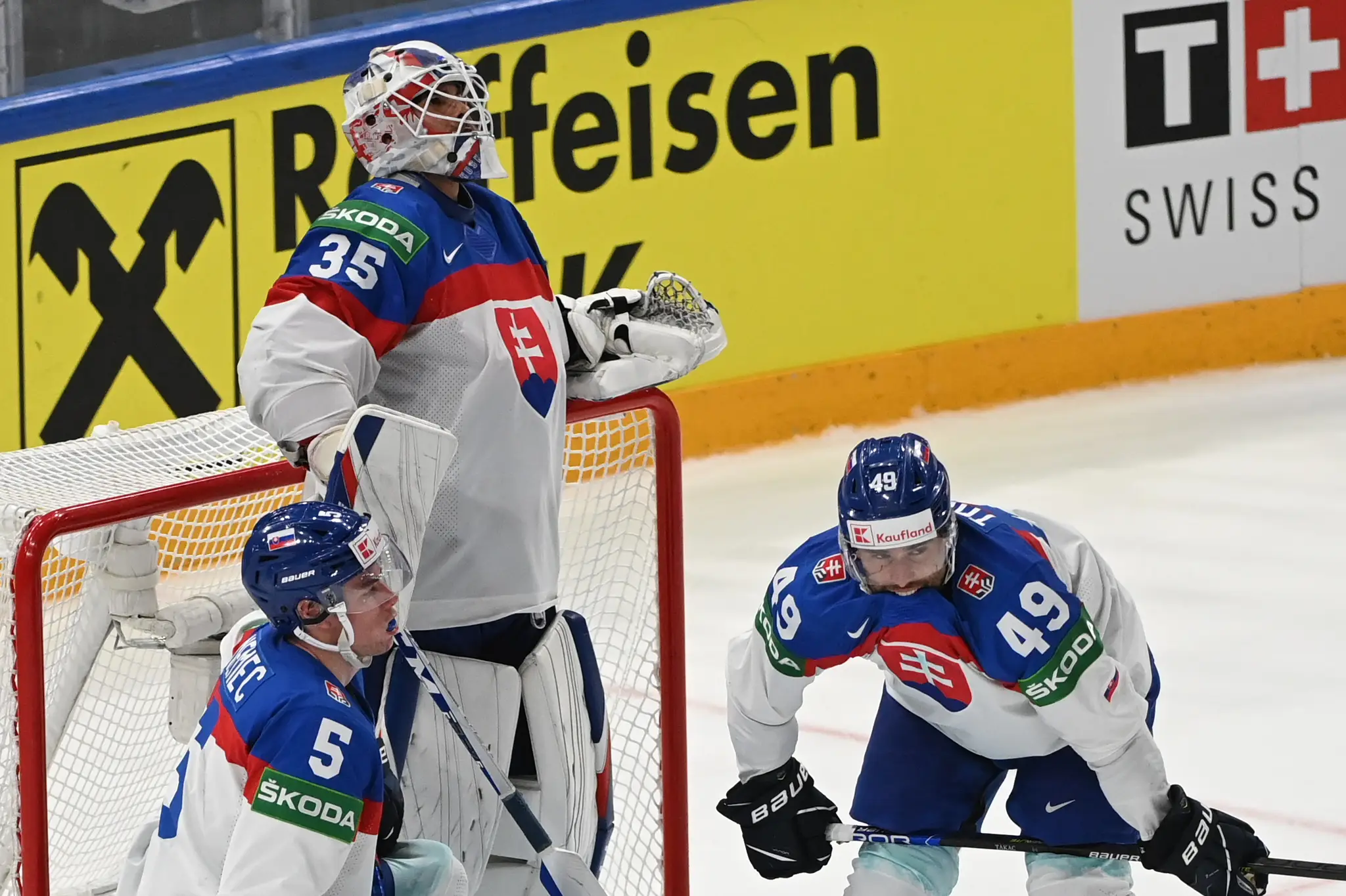 Zľava Šimon Nemec, Adam húska a Samuel Takáč smútia po prehre s Fínskom vo štvrťfinále MS 2022.