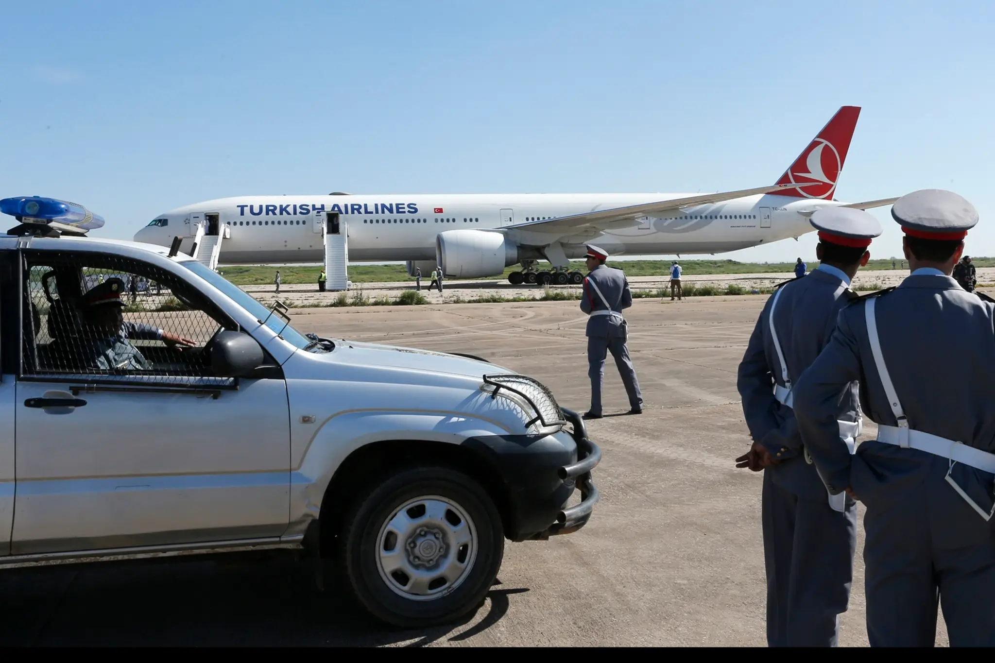 Policajti stoja vedľa lietadla tureckých aerolínií na letisku v Casablance