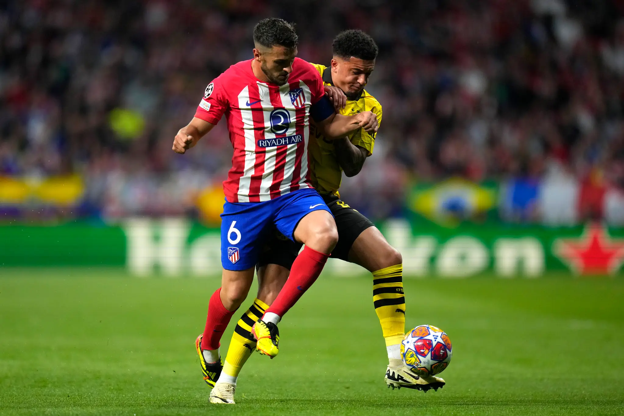 Hráč Atletico Madrid Koke (vľavo) bojuje o loptu s Jadonom Sanchom z Dortmundu.