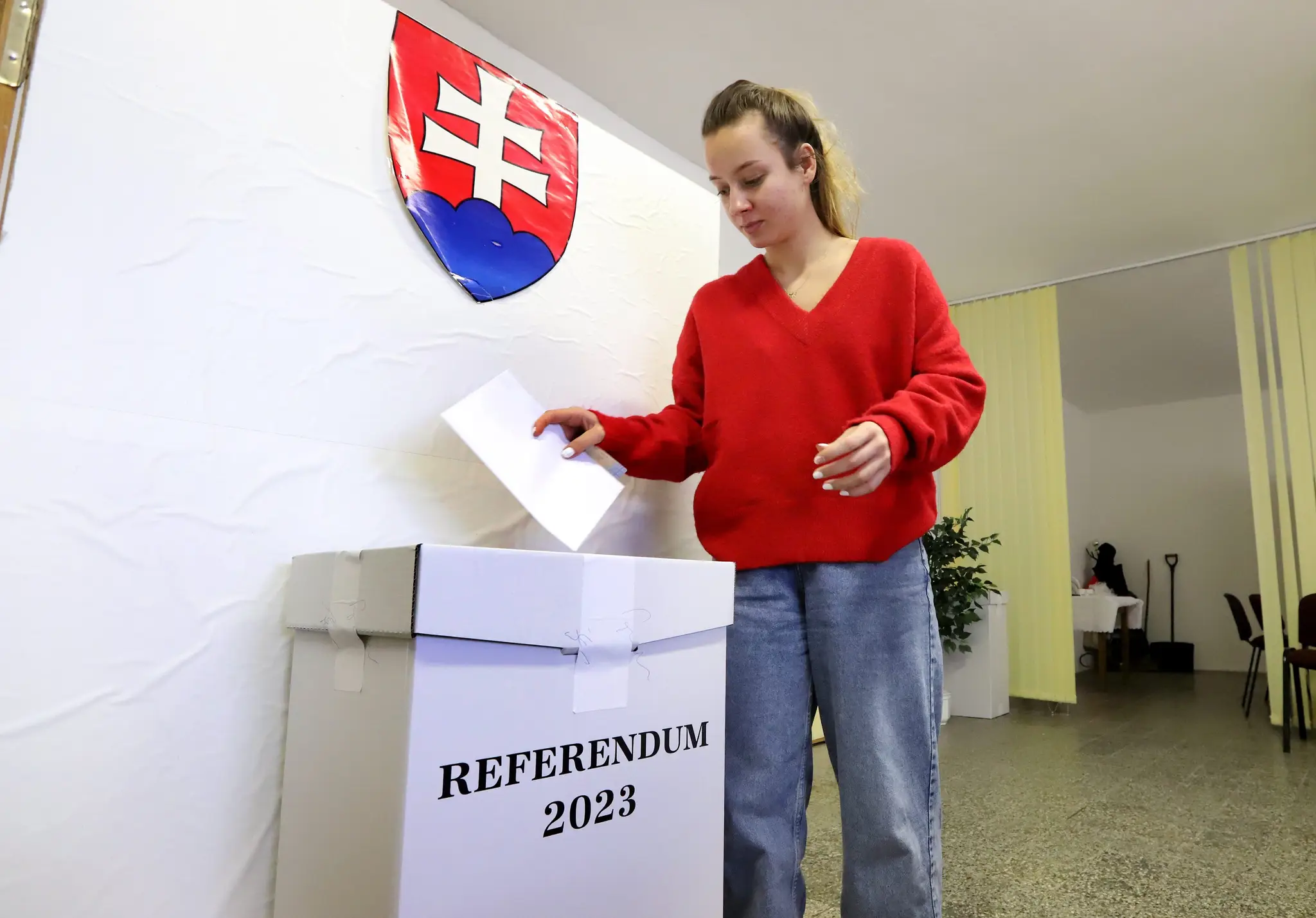 Volička vhadzuje obálku s hlasovacím lístkom do volebnej schránky v malej obci Bacúrov.