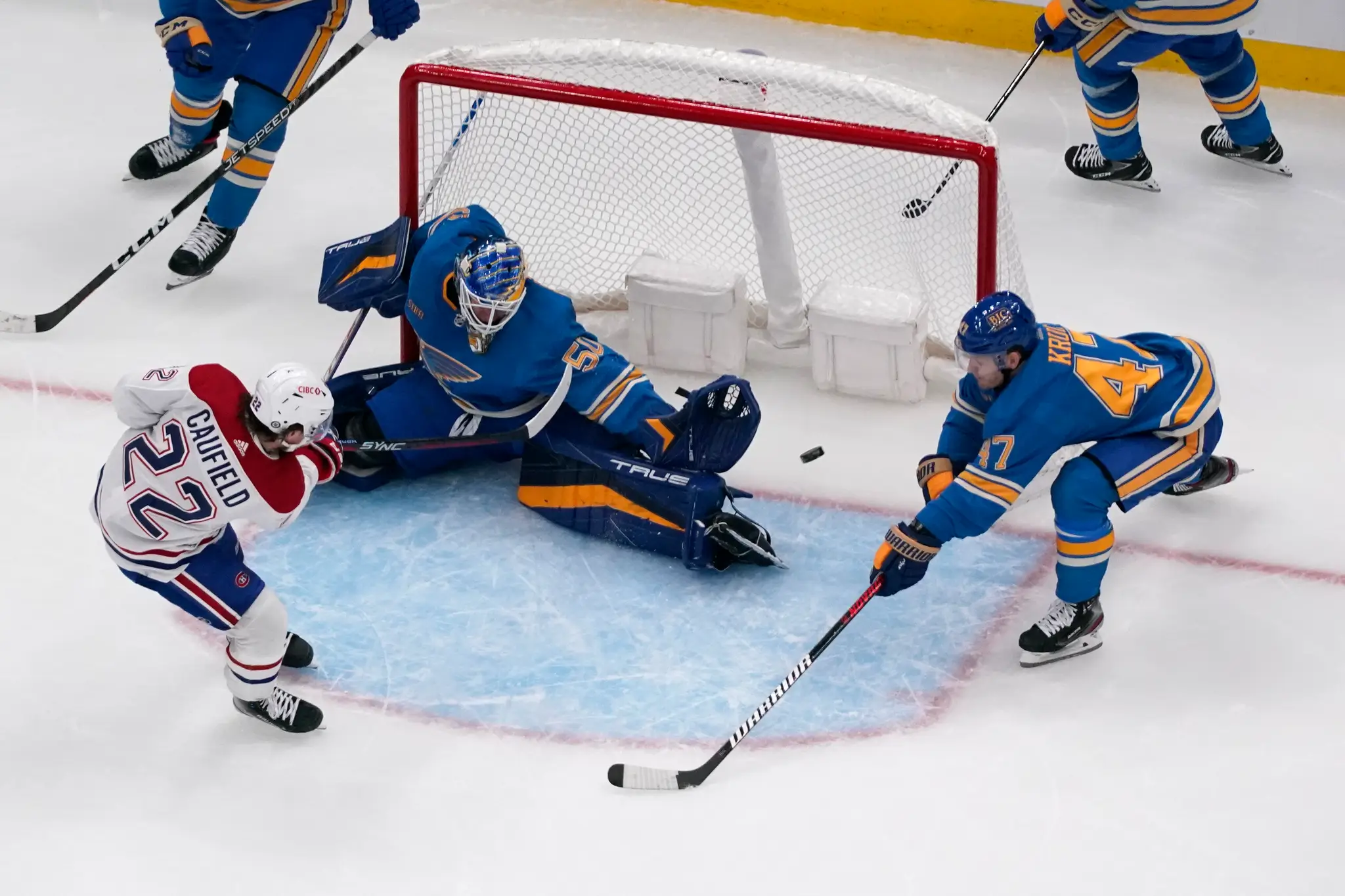 Hokejista Montrealu Canadiens Cole Caufield (vľavo) prekonáva brankára St. Louis Blues Jordana Binningtona