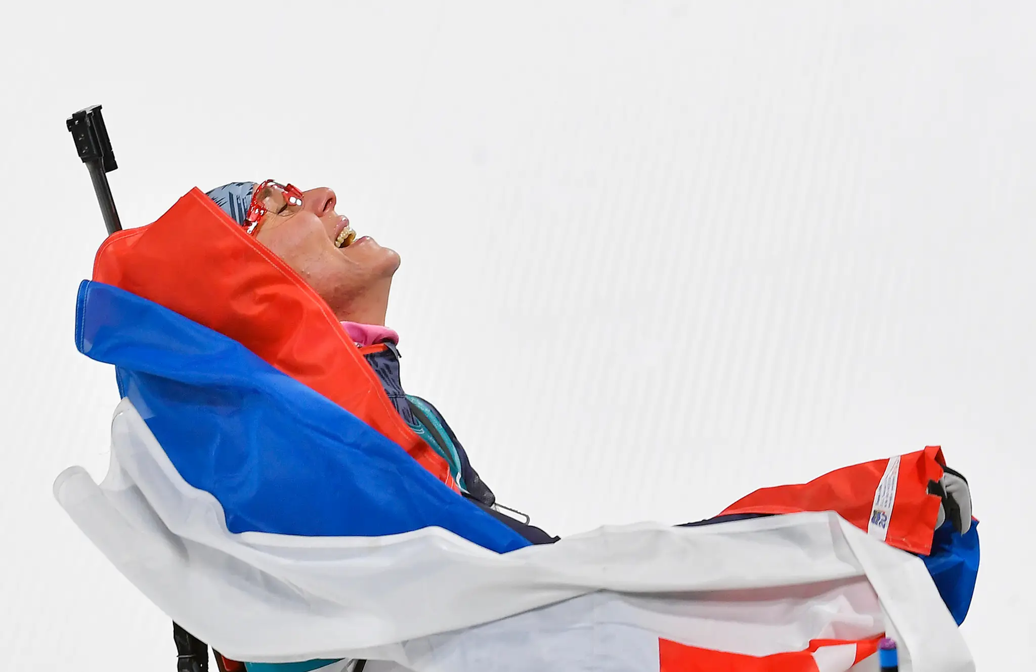 Anastasia Kuzminová sa teší v cieli po zisku zlatej olympijskej medaily počas pretekov žien s hromadným štartom na 12,5 km.
