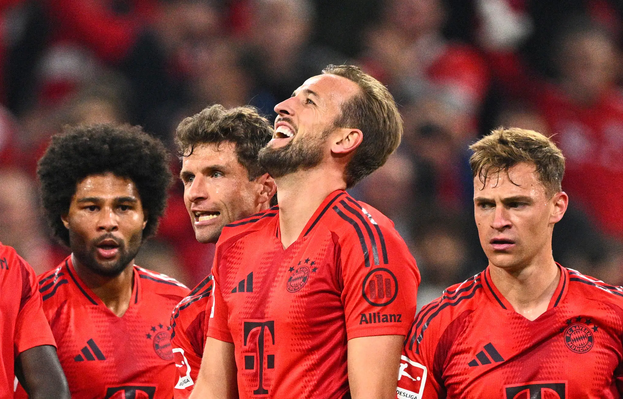 Futbalista Bayernu Mníchov Harry Kane (druhý sprava) sa teší z gólu.