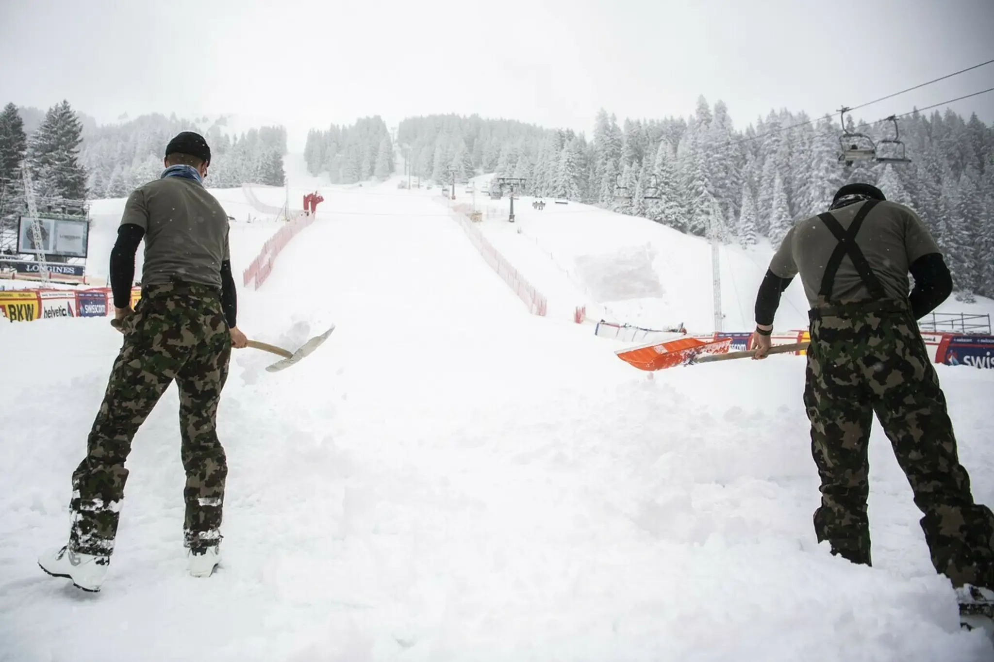 Vojaci odpratávajú sneh v dolnej časti zjazdovky v Lenzerheide.