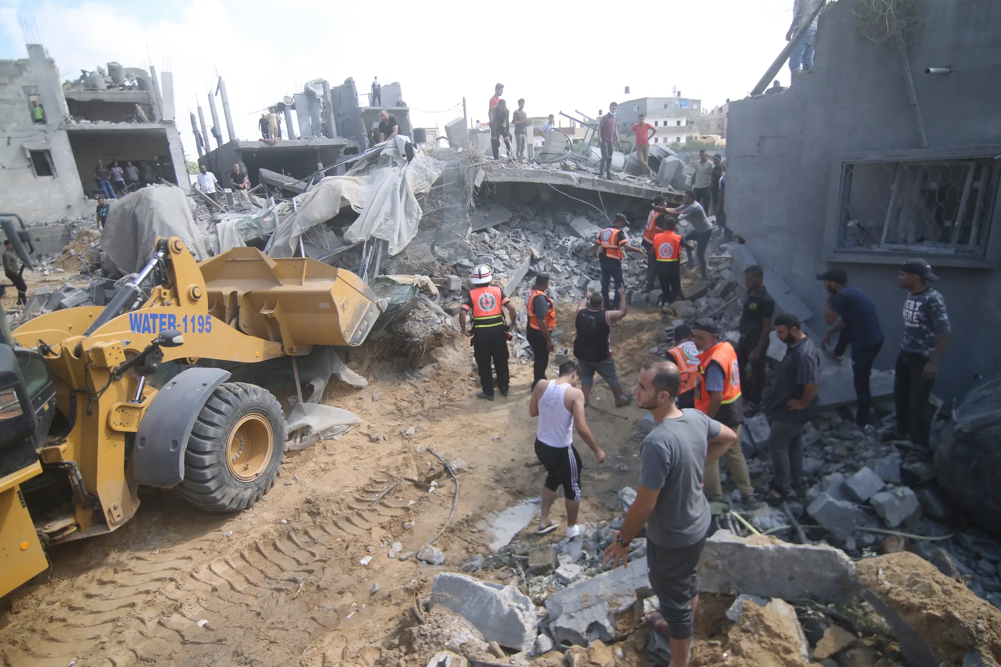 Palestínčania pátrajú po preživších po izraelskom leteckom útoku v utečeneckom tábore Rafah na juhu pásma Gazy.
