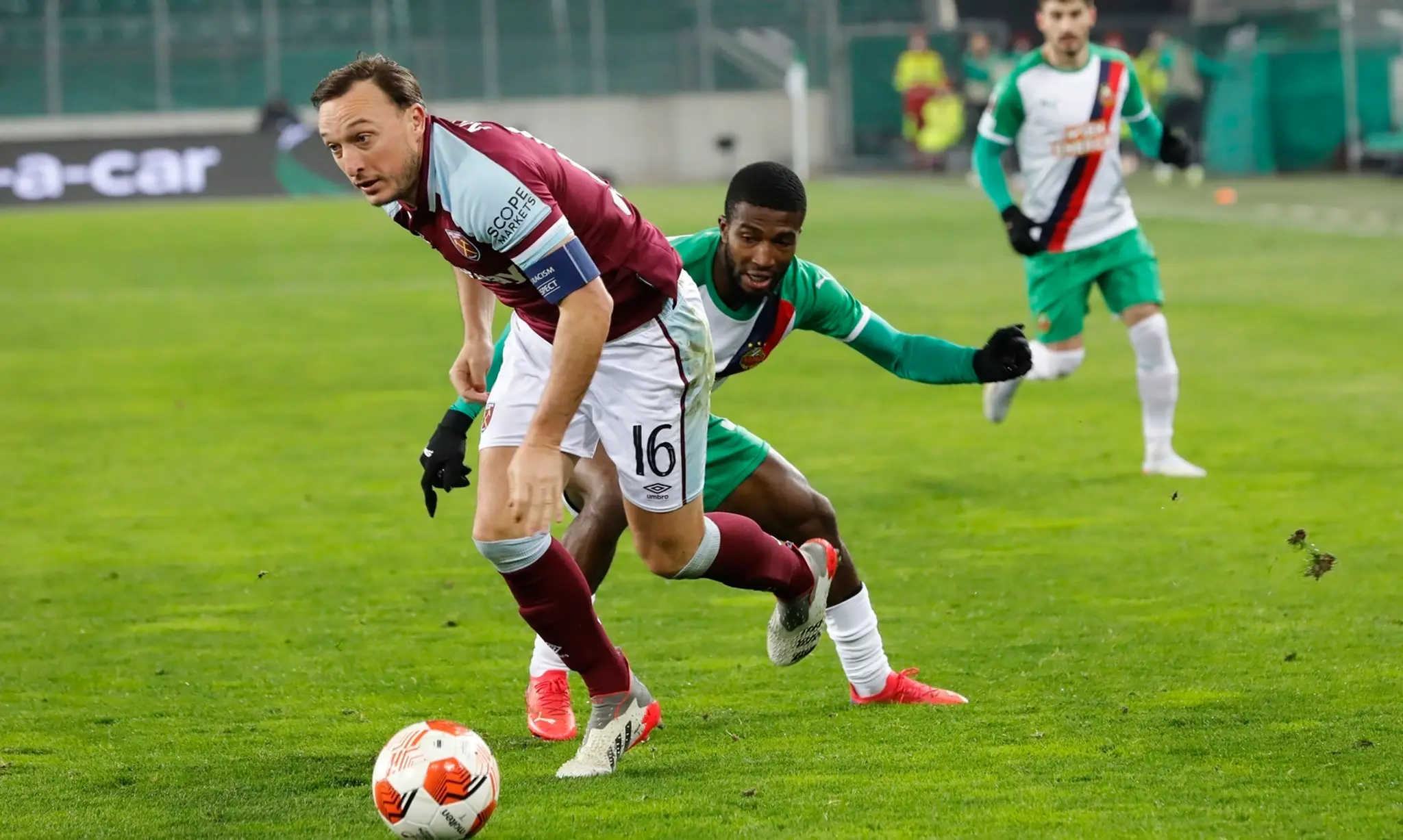 Mark Noble (West Ham) v súboji o loptu s Kelvinom Arasem z Rapidu Viedeň.