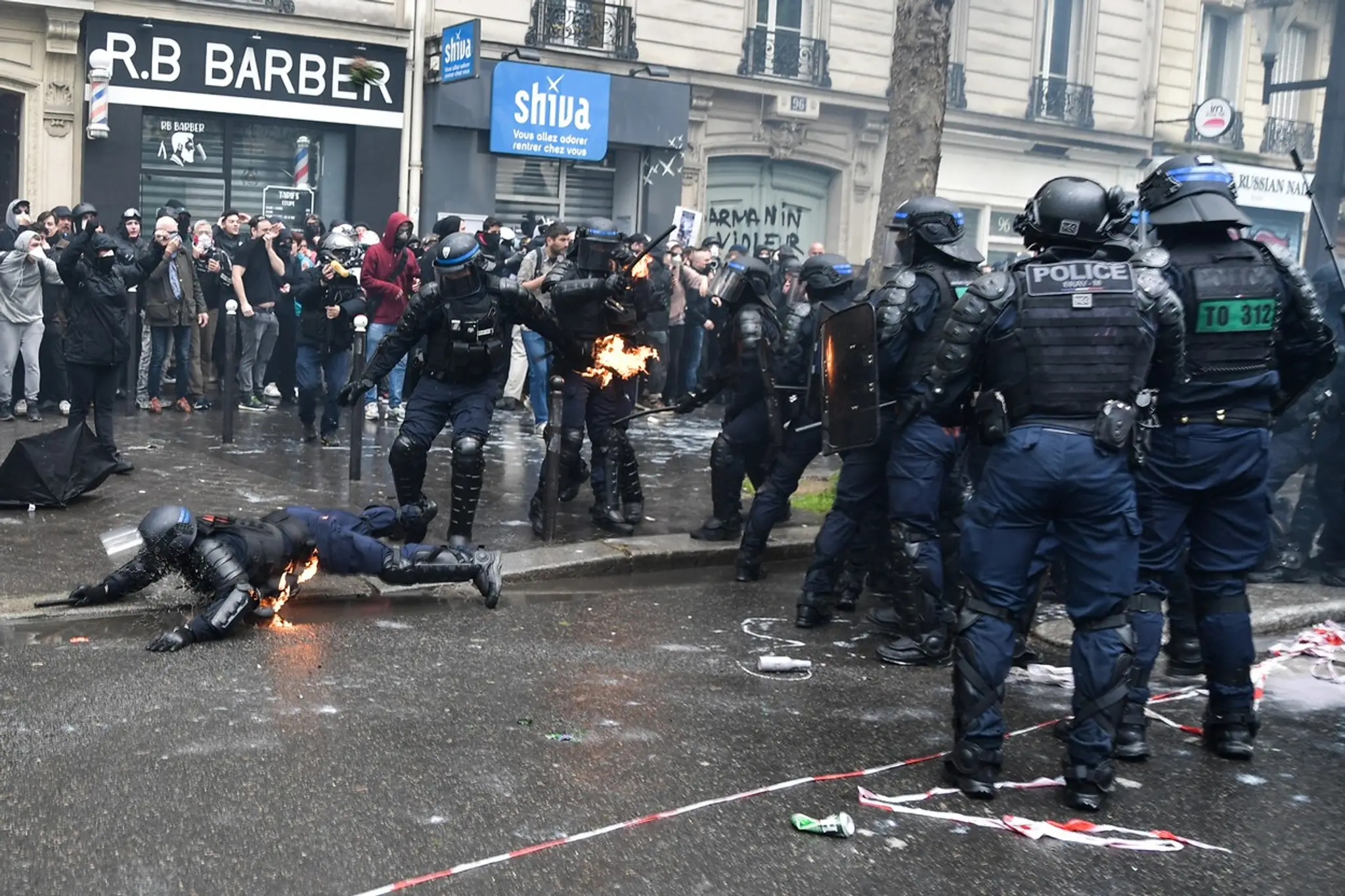 NA snímke sú zachytené demonštrácie vo Francúzku. Na fotke sú demonštranti aj policajti. Jeden z policajtov leží na zemi.