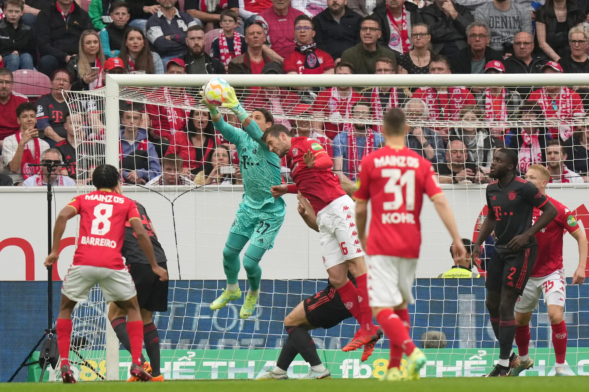 Brankár Bayernu Yann Sommer chytá loptu pred Stefanom Bellom z Mainzu.