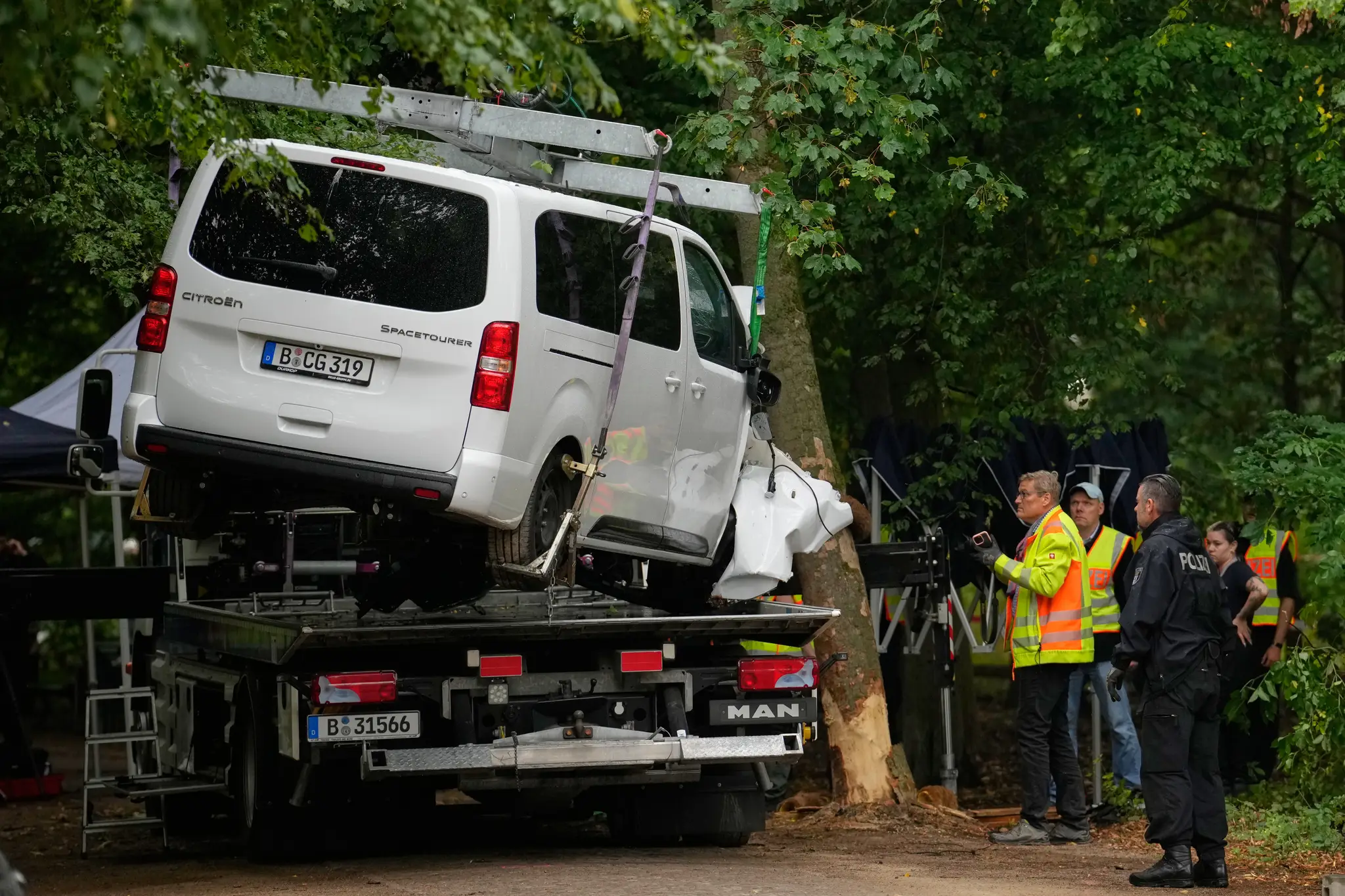 Na snímke policajti odvážajú auto, ktoré narazilo do stromu po tom, čo vrazilo do davu ľudí počas pochodu Pride v Berlíne.