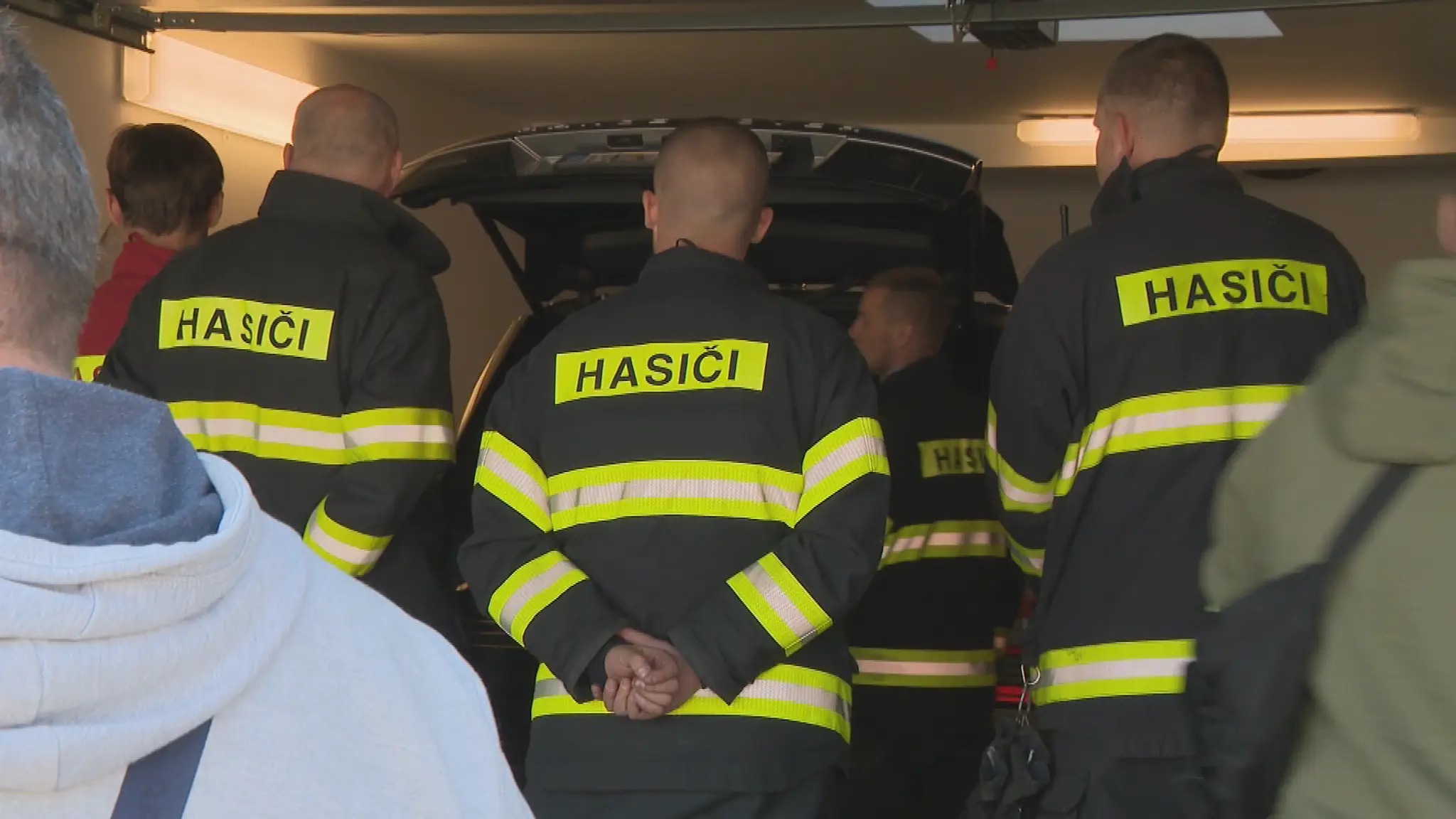 Hasiči a polícia pri aute.