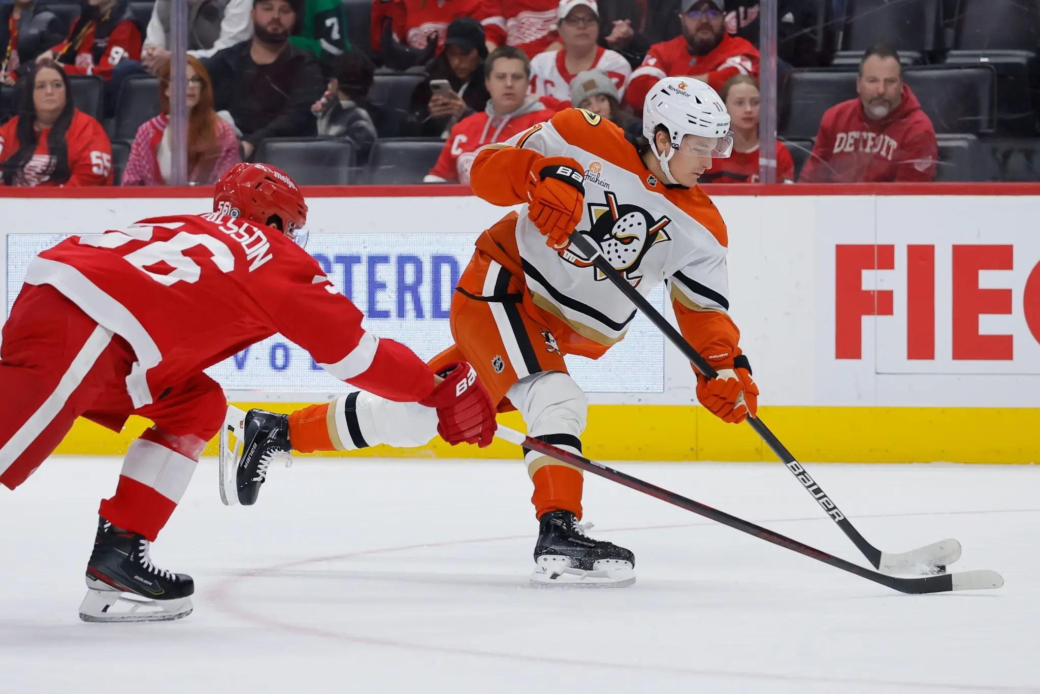 Hokejista Anaheimu Ducks Trevor Zegras (vpravo) a hráč Detroitu Erik Gustafsson bojujú o puk