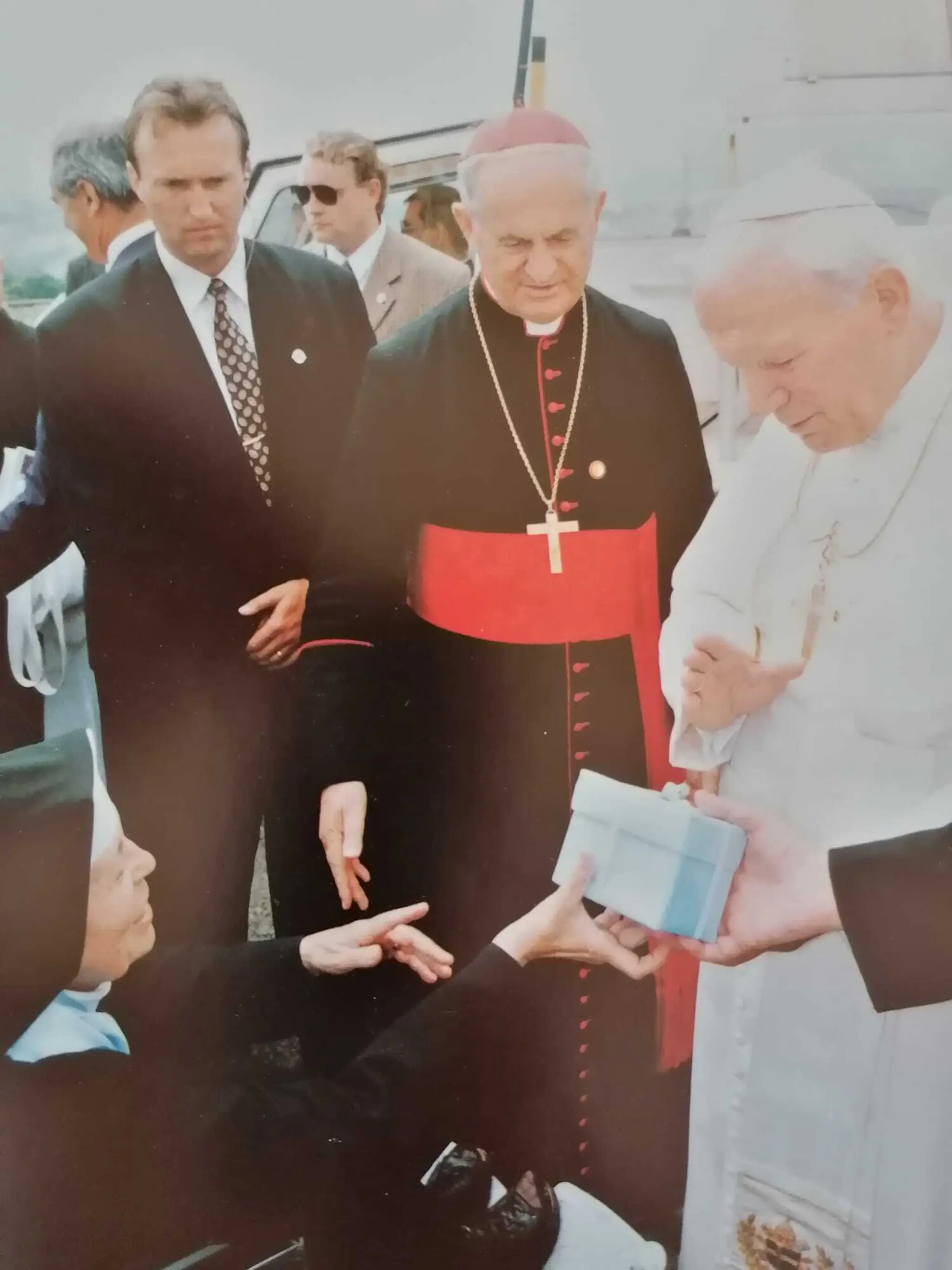 Pápež Ján Pavol II. odovzdáva dar mníške, v pozadí kardinál Jozef Tomko, za ním Juraj Zábojník.