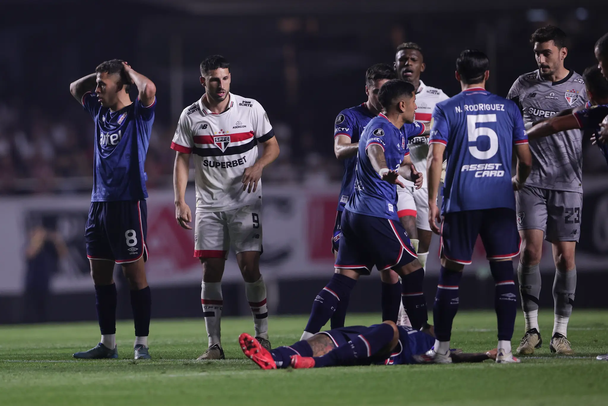 Uruguajský futbalista Juan Izquierdo (dole) z Nacionalu Montevideo leží na trávniku po kolapse počas zápasu  juhoamerického Pohára osloboditeľov.