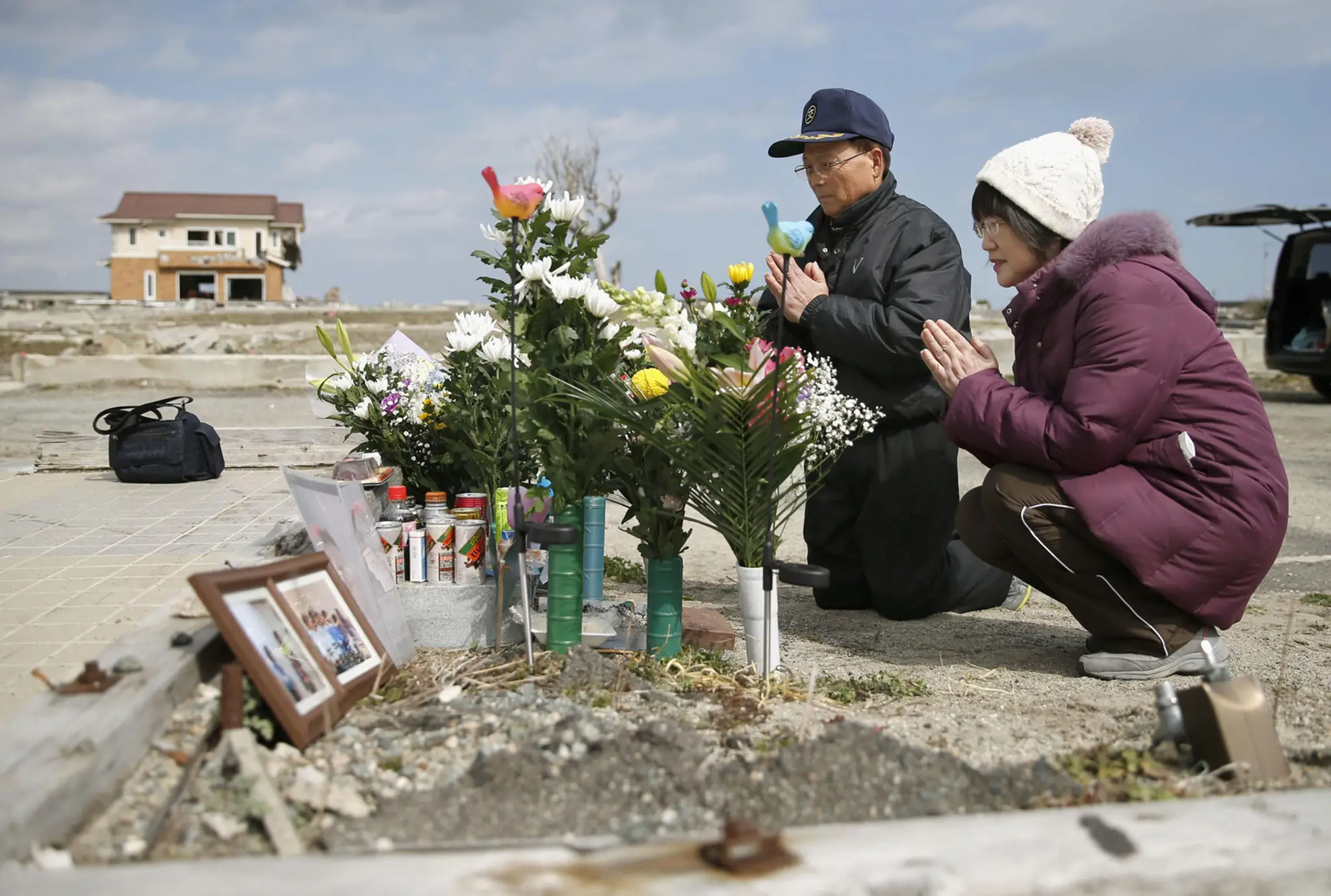 anželia sa modlia za svoju dcéru, ktorá zahynula v roku 2011 počas ničivého cunami v japonskom Namie v profektúre Fukušima.