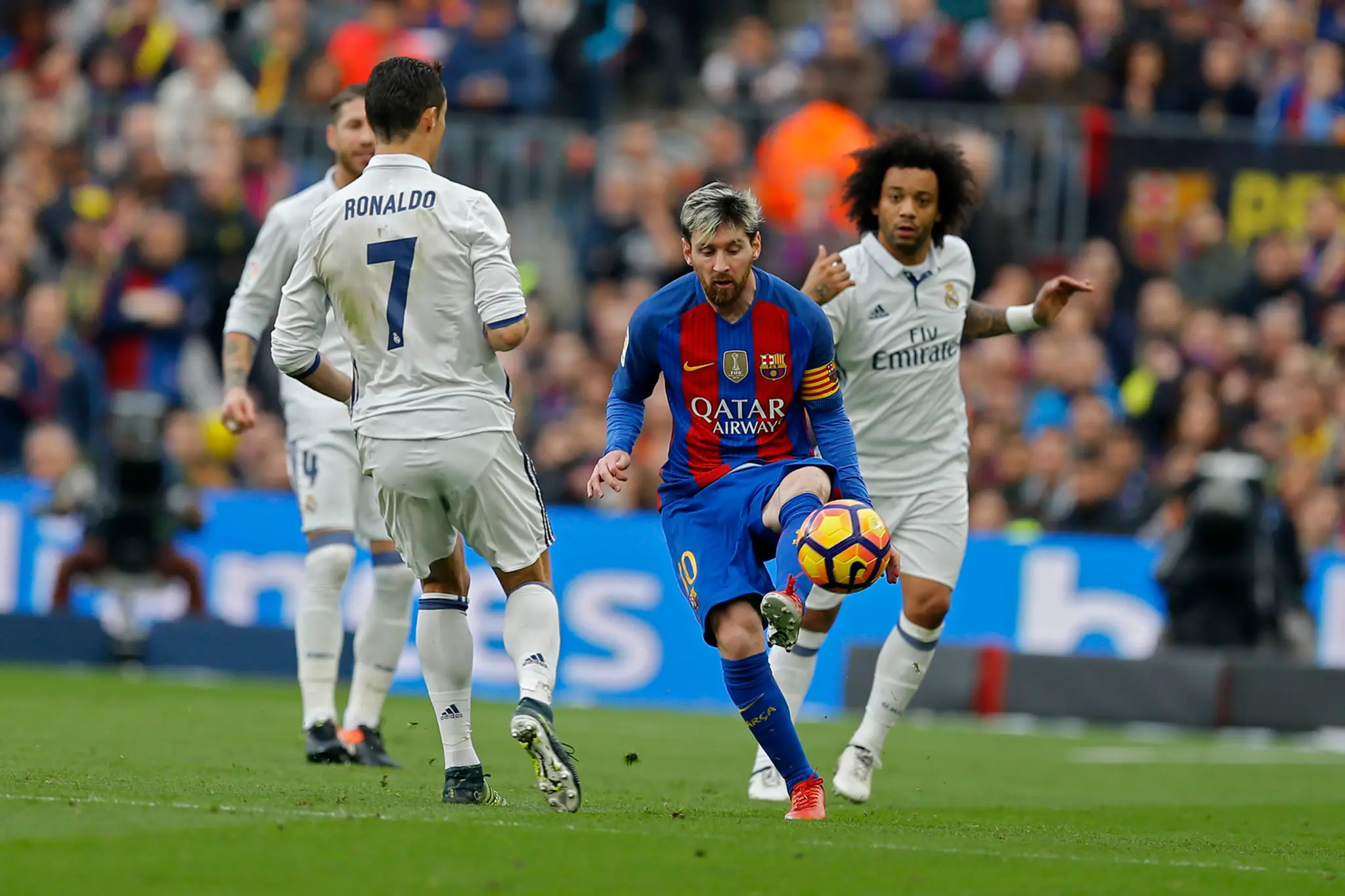 Kapitána Barcelony Lionela Messiho (v strede) sa v El Clásicu snaží obrať o loptu bek Realu Marcelo (vpravo), prizerá sa Cristia