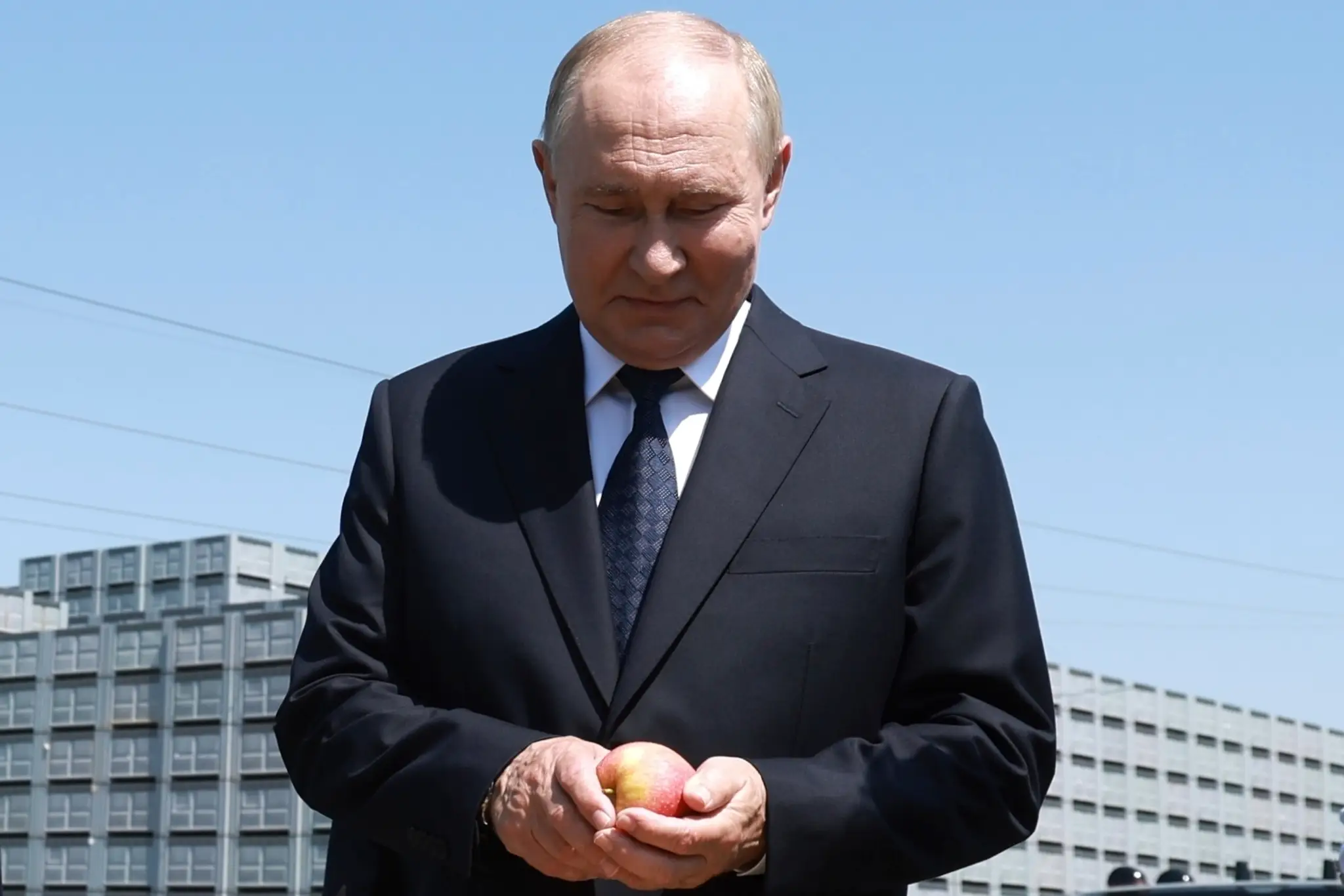 Vladimir Putin si prezerá jablko v utorok 20. augusta 2024.