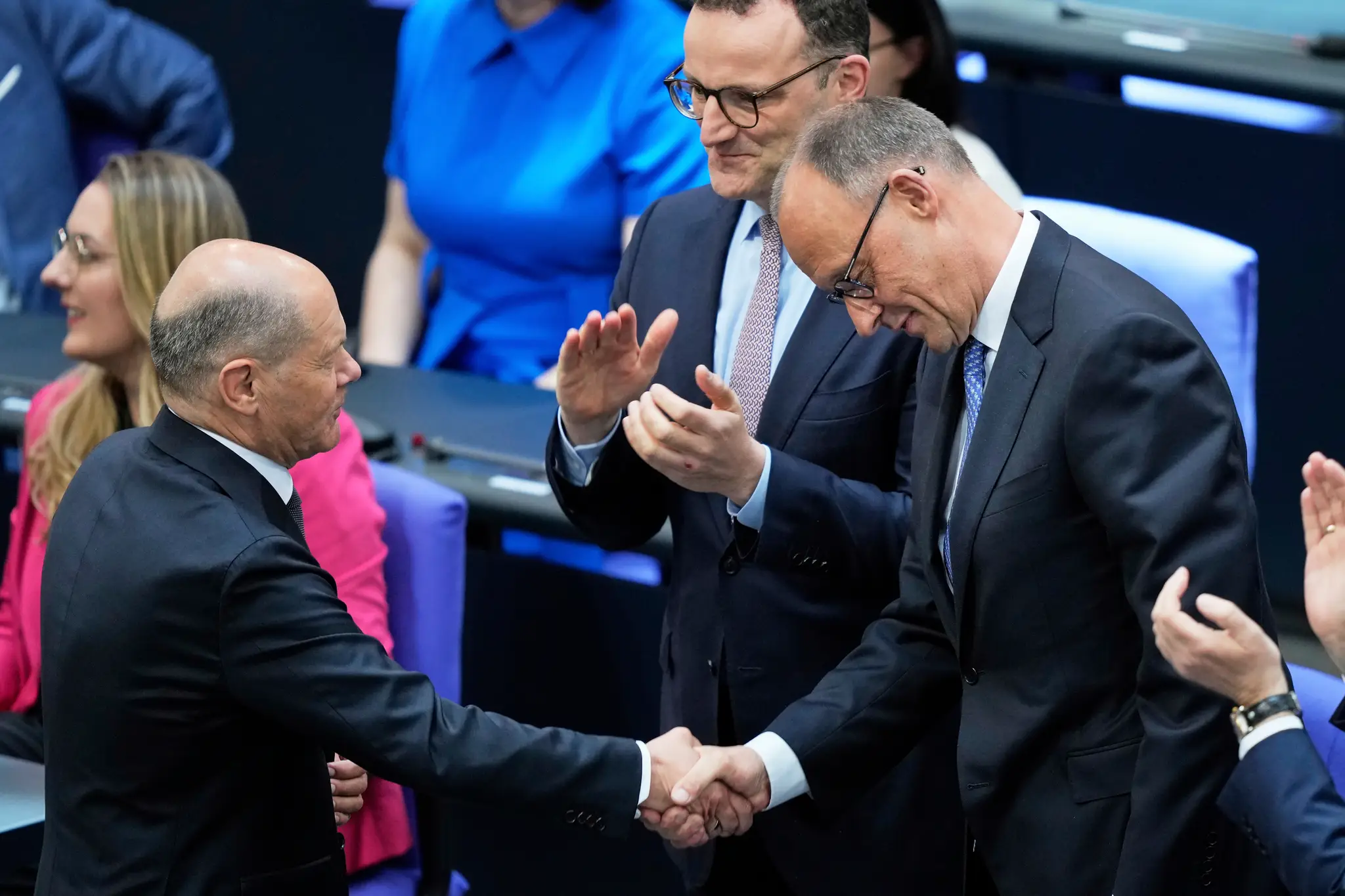 Odchádzajúci nemecký kancelár Olaf Scholz (vľavo) gratuluje lídrovi nemeckých kresťanských demokratov (CDU) Friedrichovi Merzovi po jeho zvolení za nového nemeckého kancelára.