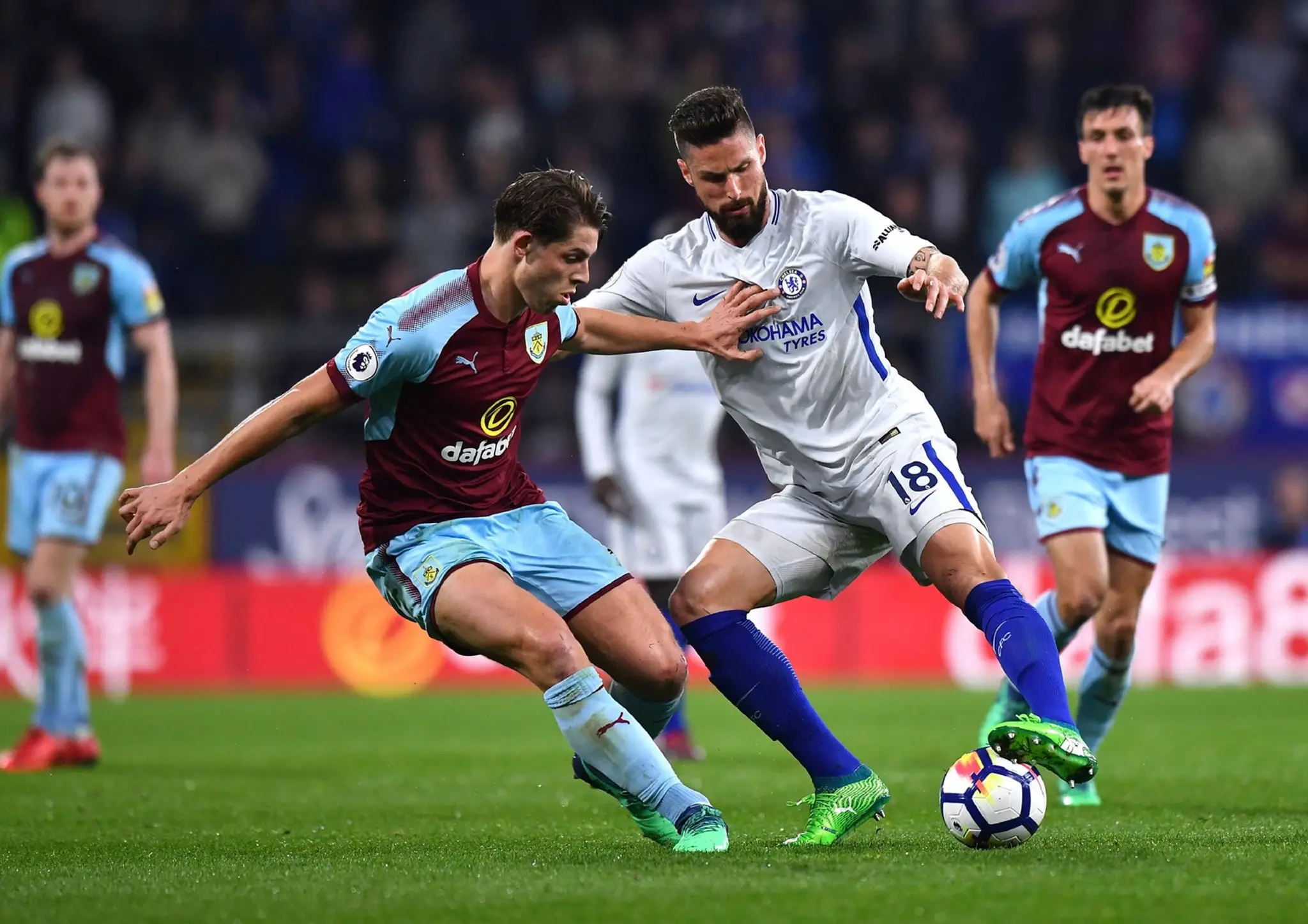 Olivier Giroud (Chelsea) s loptou a dobiedzajúci Mark Tarkowski (Burnley).