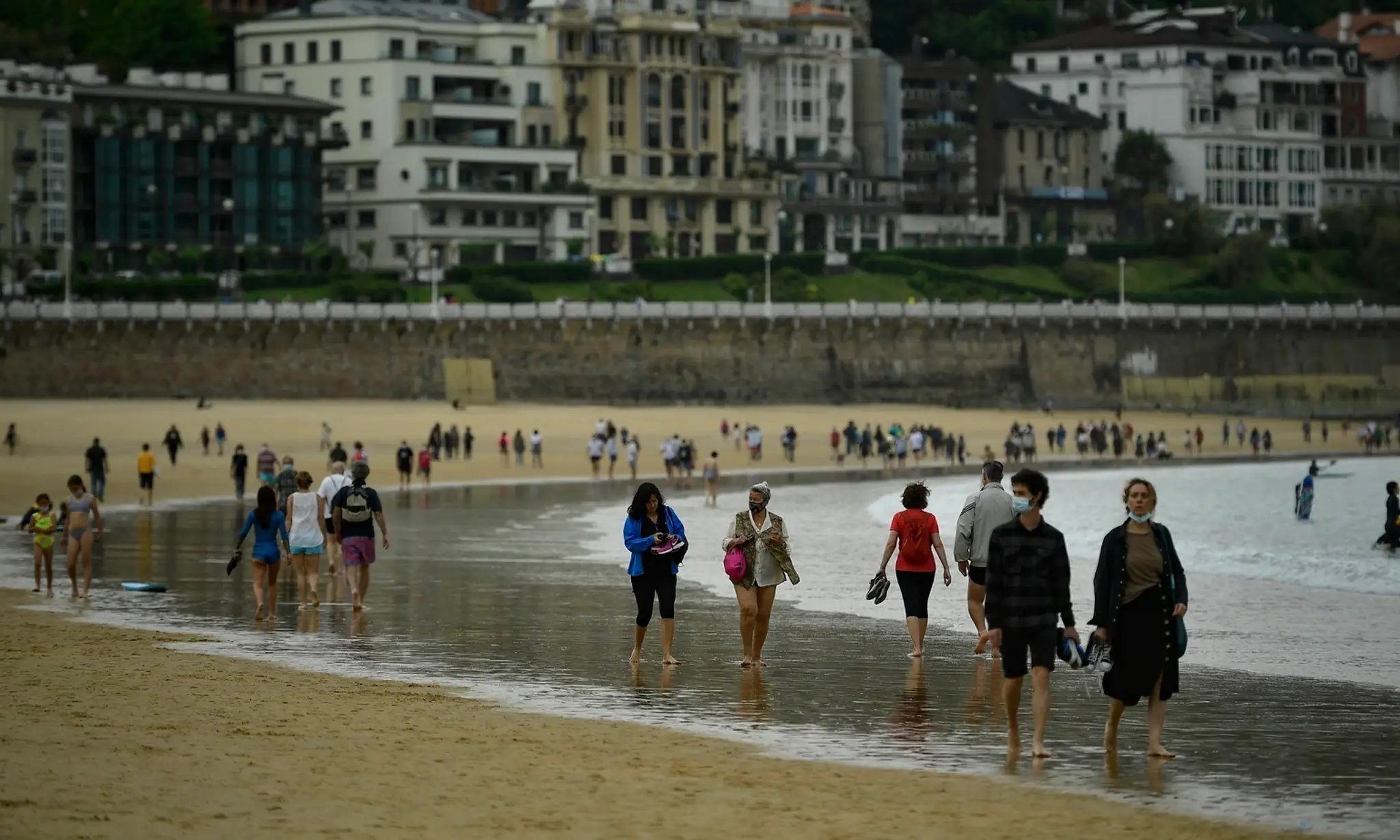 Ľudia kráčajú po pláži po zrušení lockdownu v severošpanielskom meste San Sebastian v nedeľu 9. mája 2021.