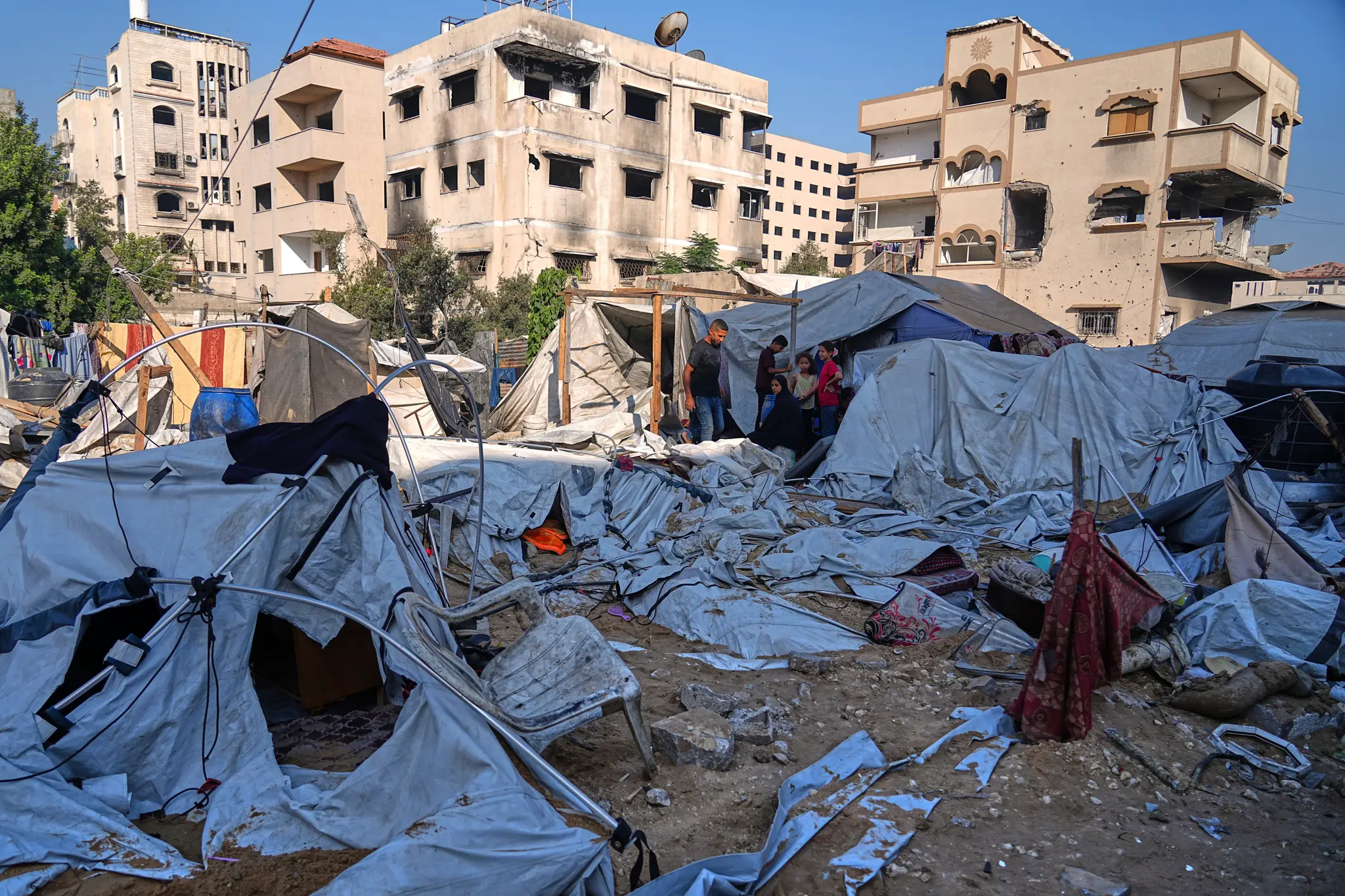 Palestínčania prehľadávajú zničené stany po izraelskom leteckom útoku na stanovú osadu, kde sa nachádzali vojnoví utečenci v centre mesta Gaza.