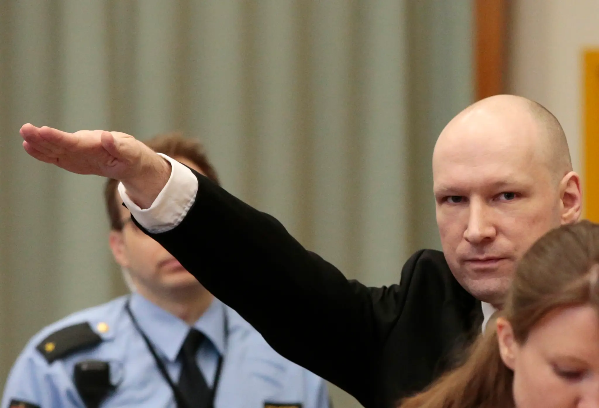 Anders Behring Breivik hajluje v súdnej sieni.