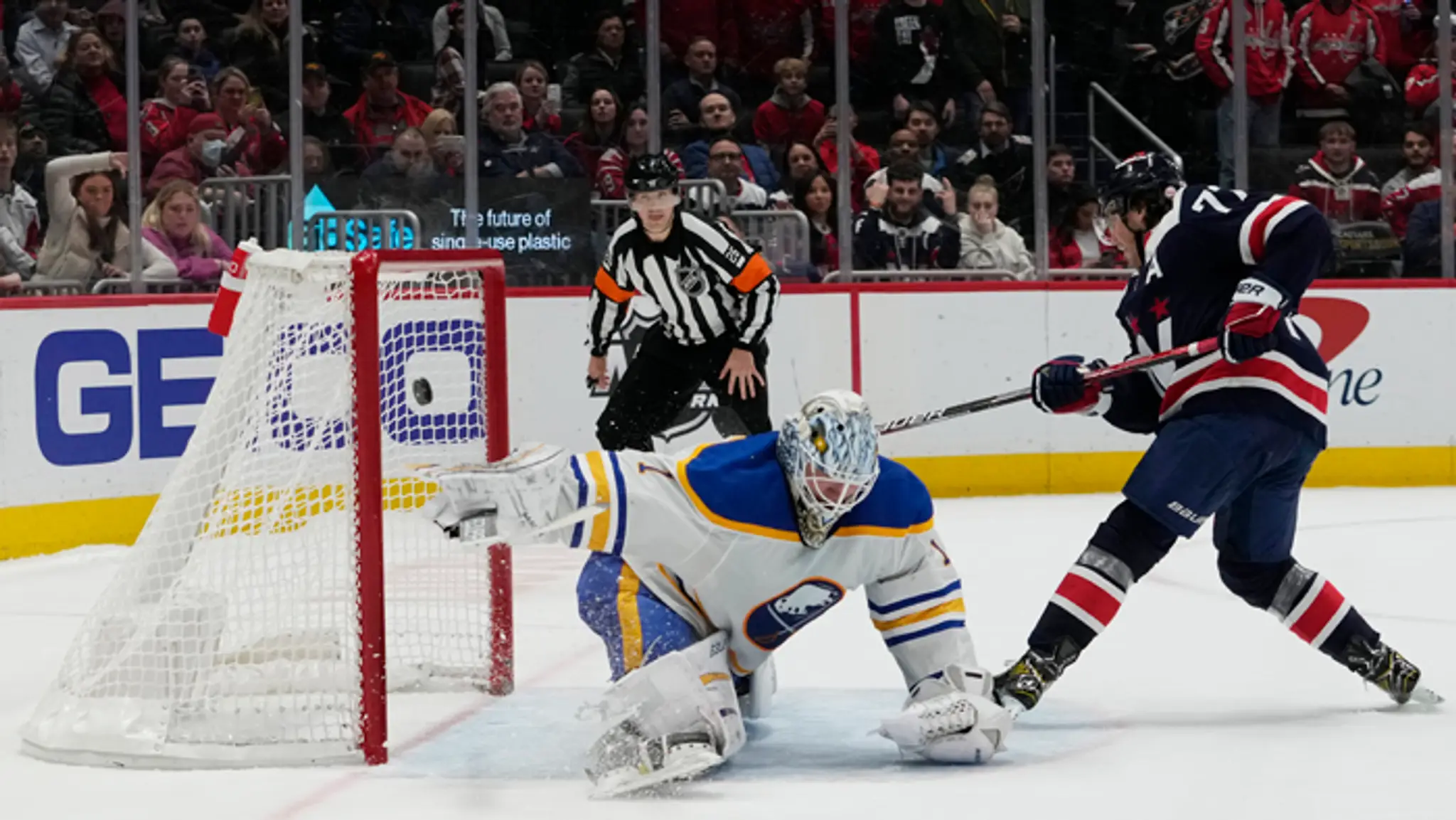 Hráč Capitals T.J. Oshie strieľa víťazný gól, vľavo prekonaný fínsky brankár Buffala Ukko-Pekka Luukkonen.