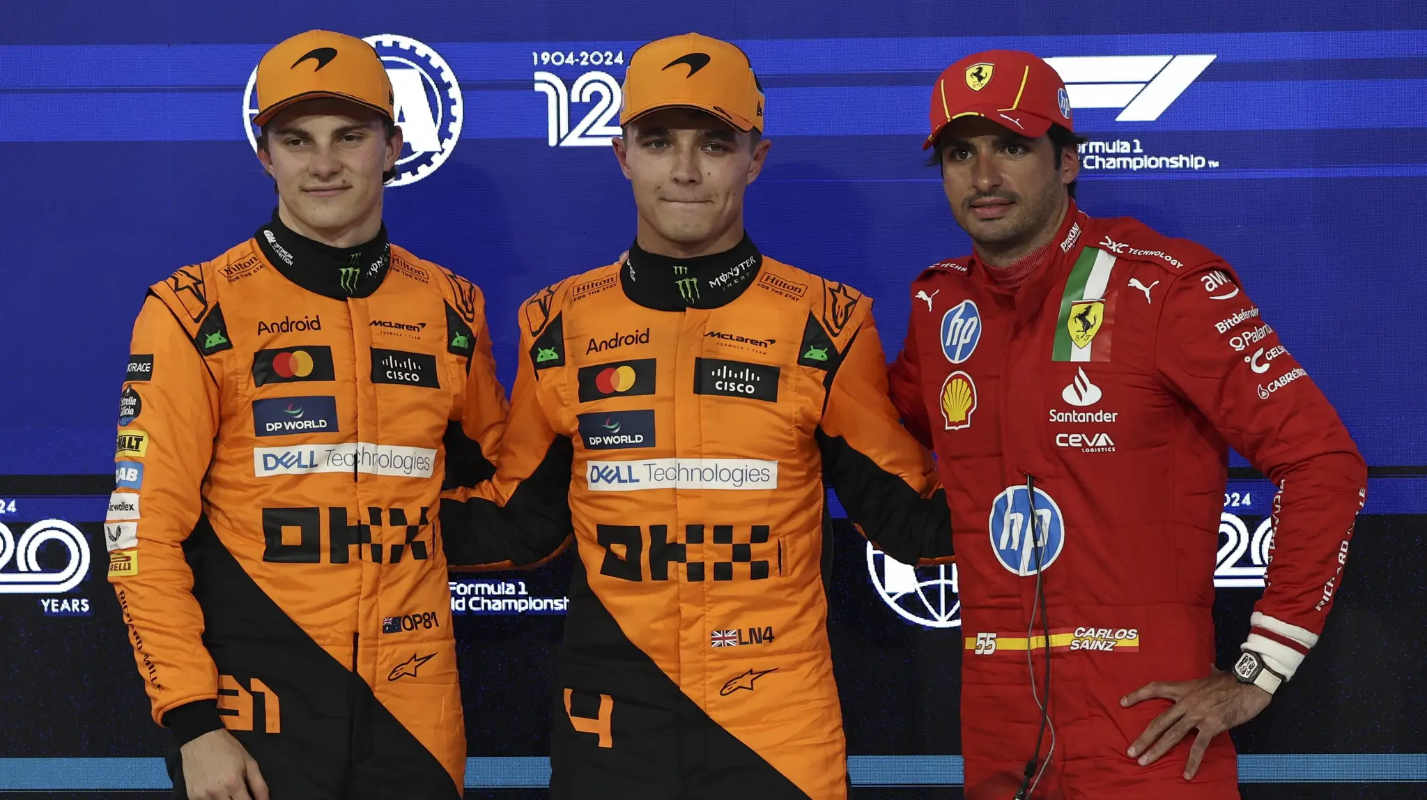 Britský pretekár Lando Norris (uprostred) na McLarene pózuje s druhým Austrálčanom Oscarom Piastrim (vľavo) a tretím   Španielom Carlosom Sainzom (vpravo) po tom, ako zvíťazil v sobotnej kvalifikácii na nedeľňajšiu Veľkú cenu Abú Zabí.