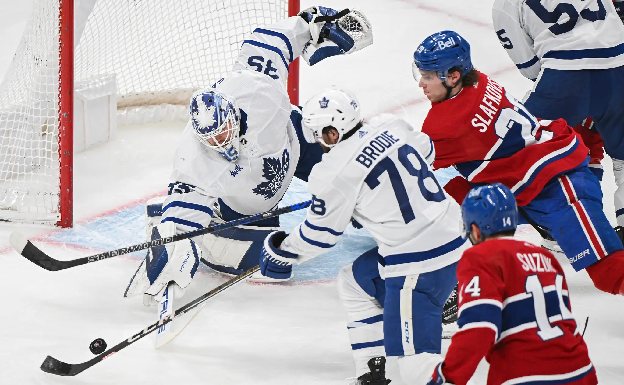 Brankár Toronto Maple Leafs Ilja Samsonov (vľavo) zasahuje pred Slovákom Jurajom Slafkovským z Montrealu Canadiens.