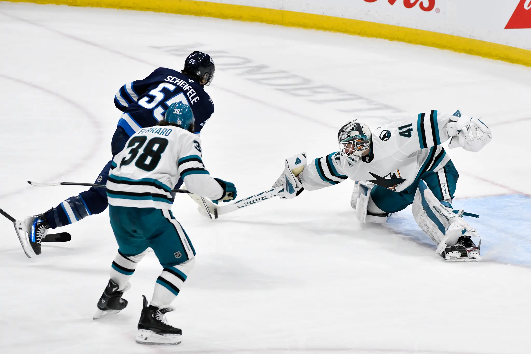 Na snímke hokejista Winnipegu Mark Scheifele (vľavo) strieľa víťazný gól.