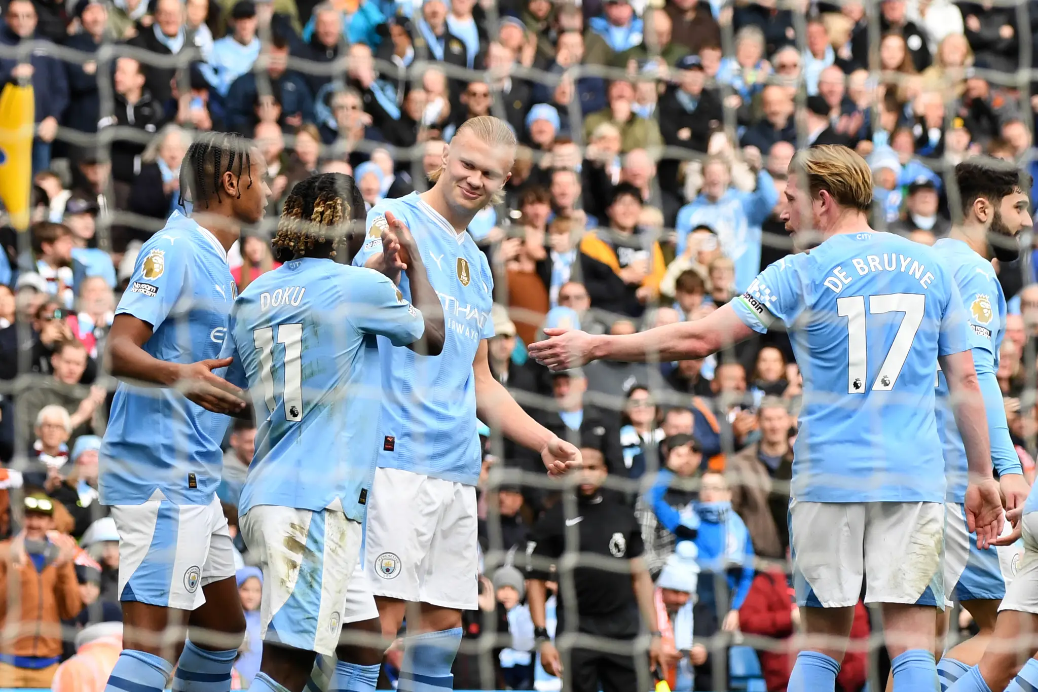 Futbalista Erling Haaland (uprostred) z Manchestru City sa teší z gólu so spoluhráčmi .