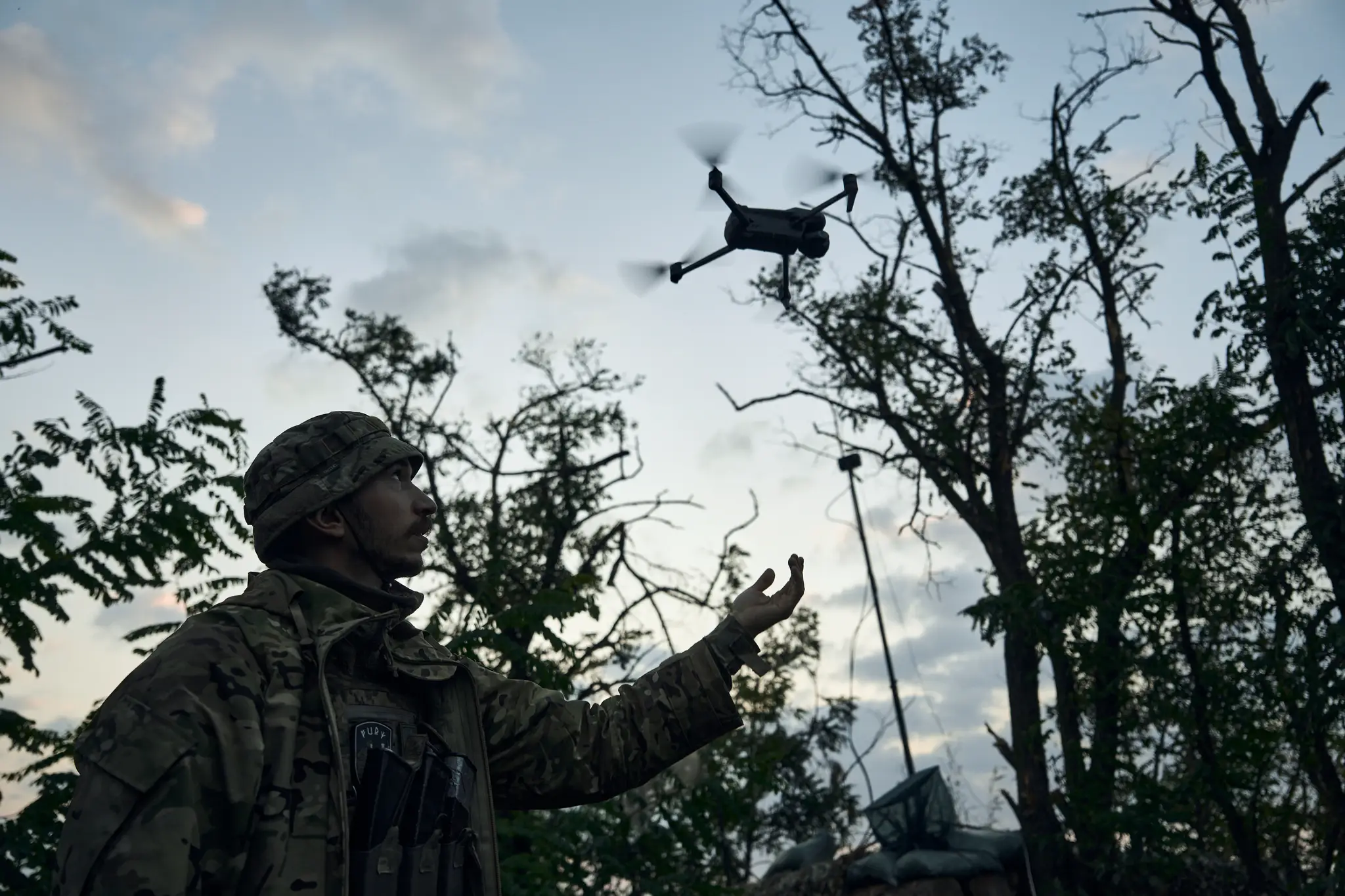 Na snímke ukrajinský vojak, ktorý vypúšťa dron.