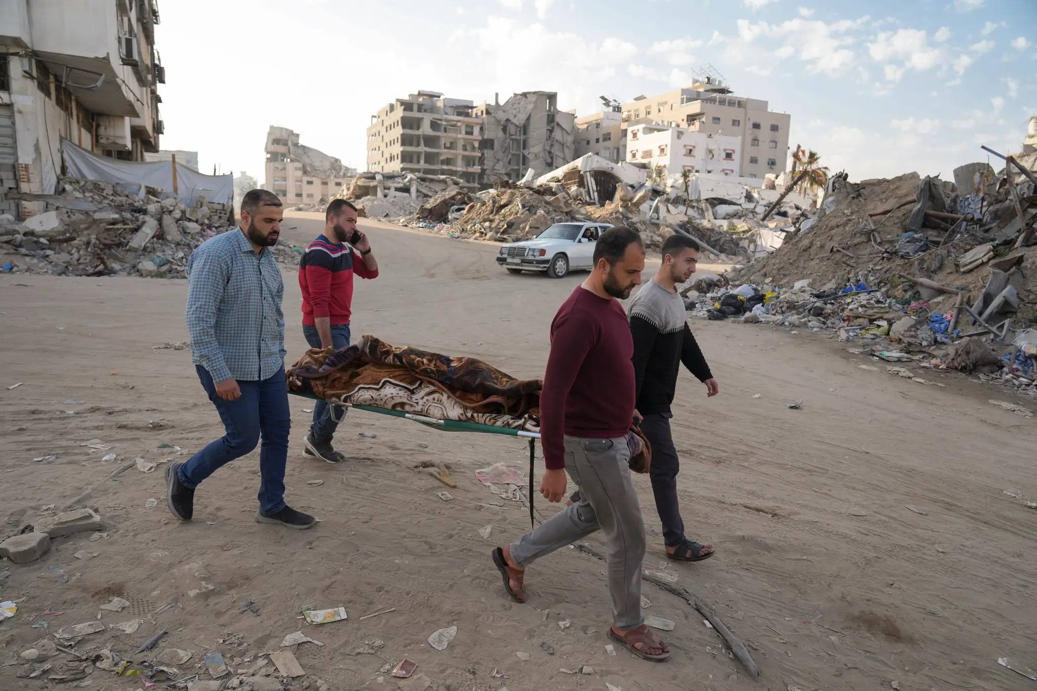 Obyvatelia Pásma Gazy prenášajú telo Palestínčana, ktorý zahynul pri izraelskom nálete. 