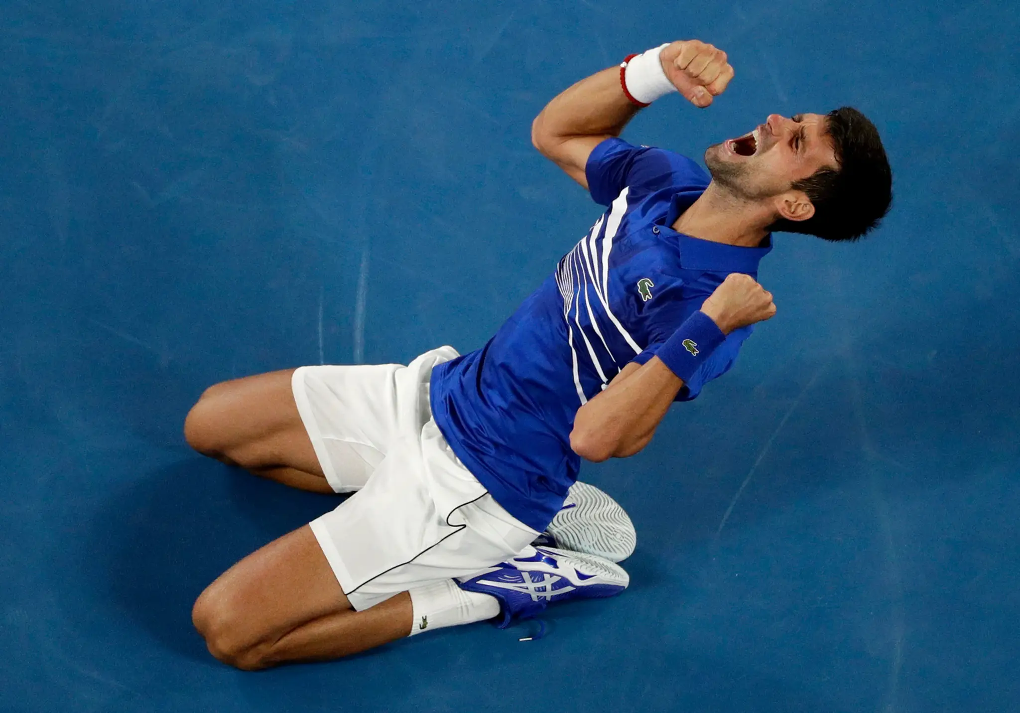 Tenista Novak Djokovič oslavuje triumf vo finále na Australian Open.