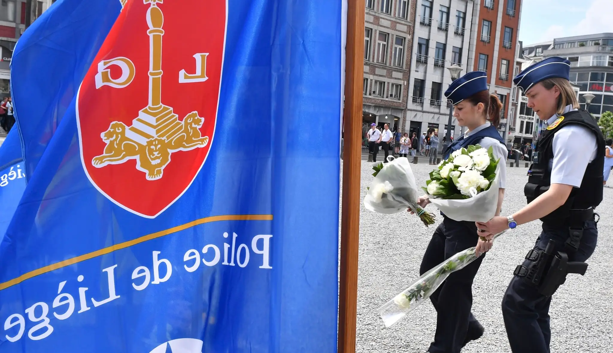 Na snímke dve policajtky kladú kvety počas minúty ticha za obete utorňajšieho útoku 30. mája 2018 v belgickom meste Liege.