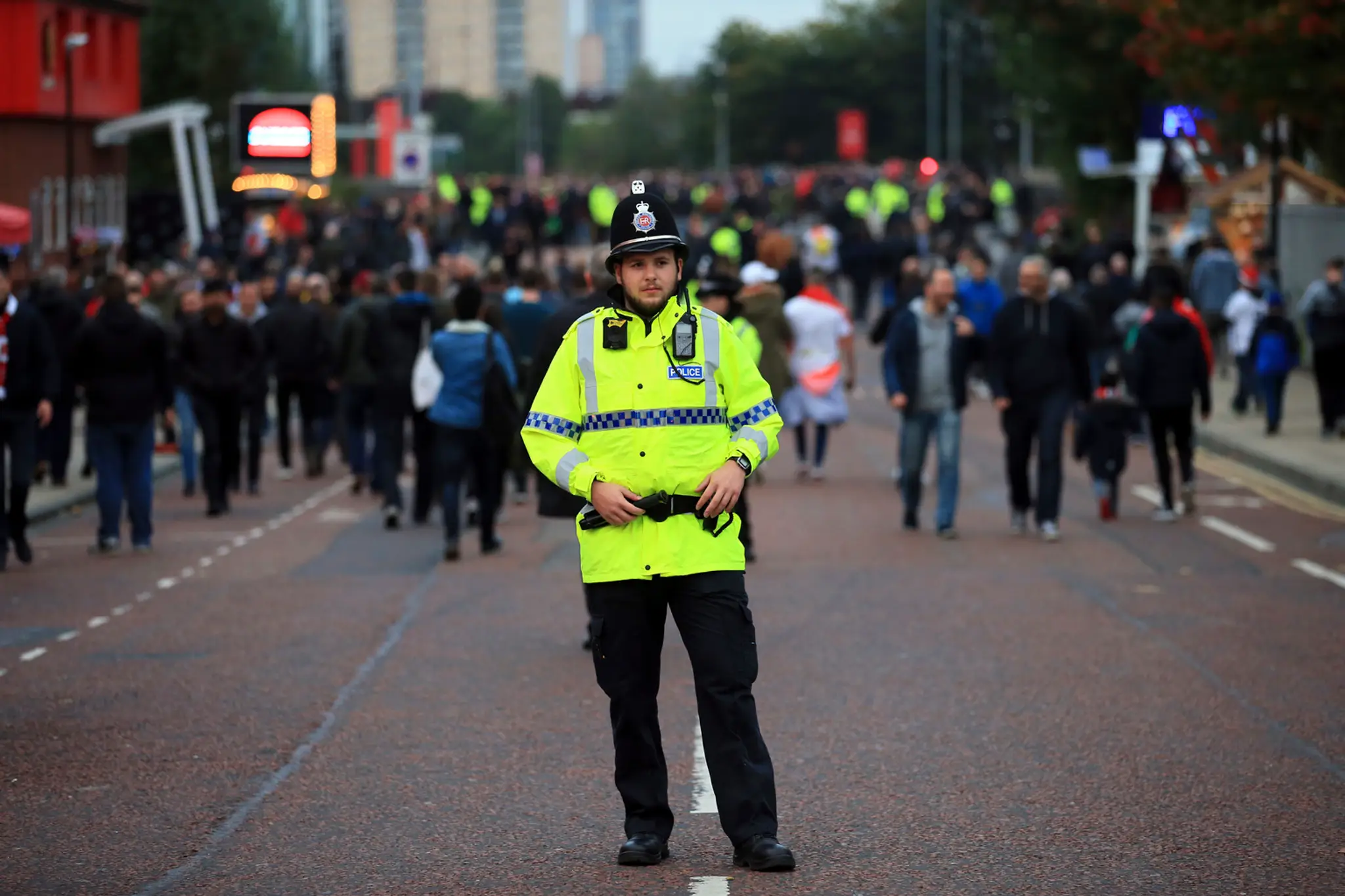 Policajt sleduje príchod fanúšikov na štadión v zápase LM ManUtd - Bern.