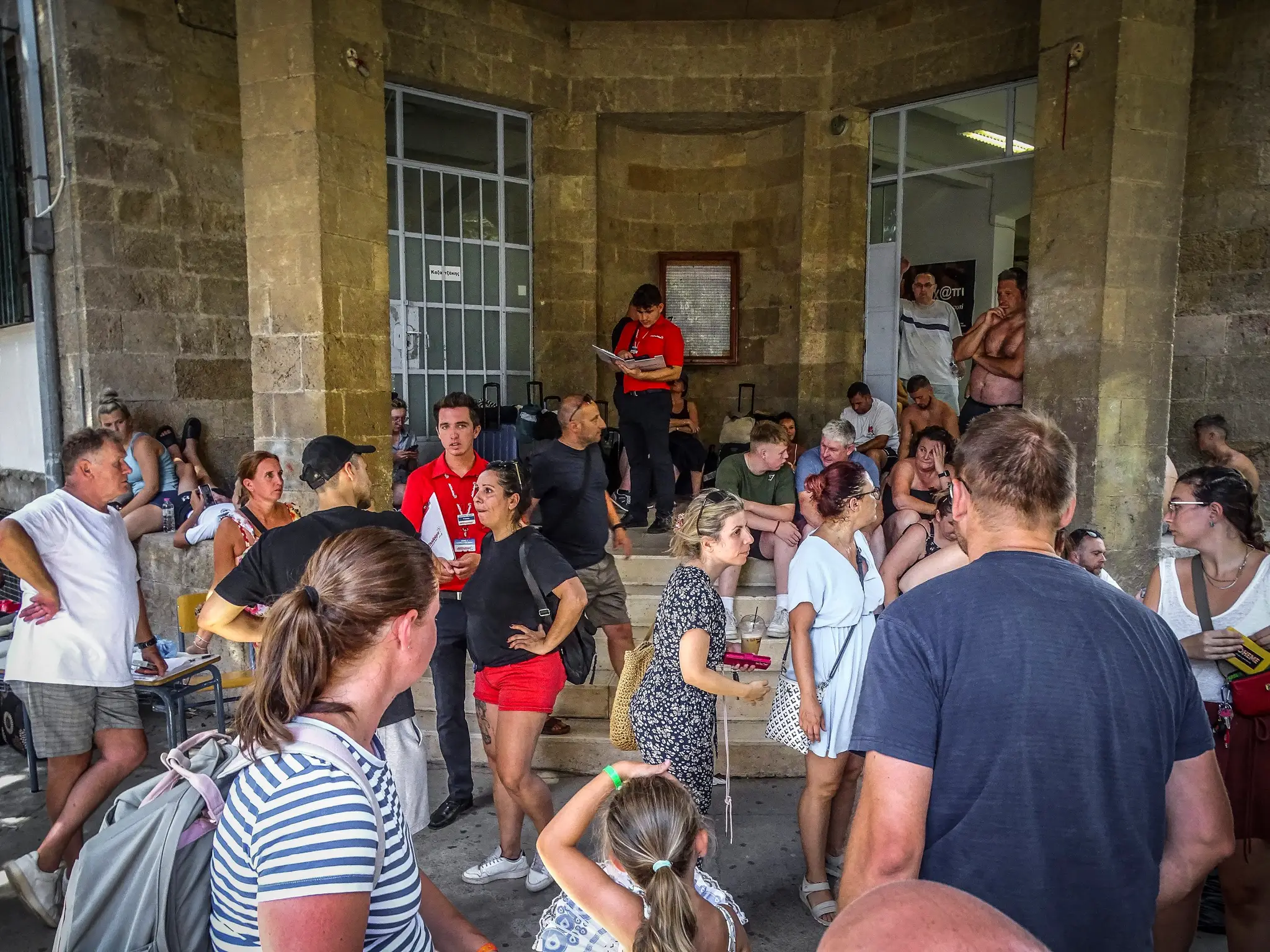 Evakuovaní turisti na Rodose stoja pred hotelom.