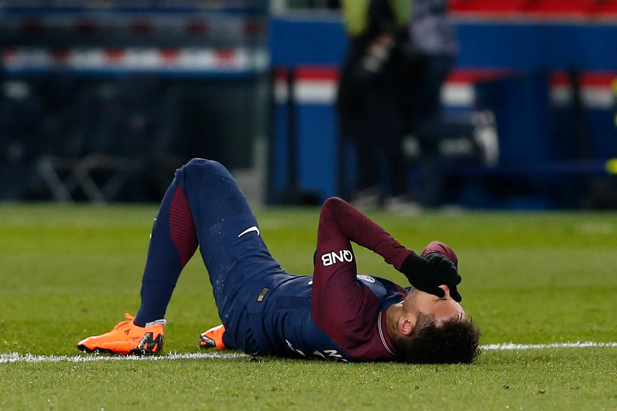 Hviezda PSG Neymar leží na trávniku po tom, čo sa zranil v ligovom zápase proti Marseille.
