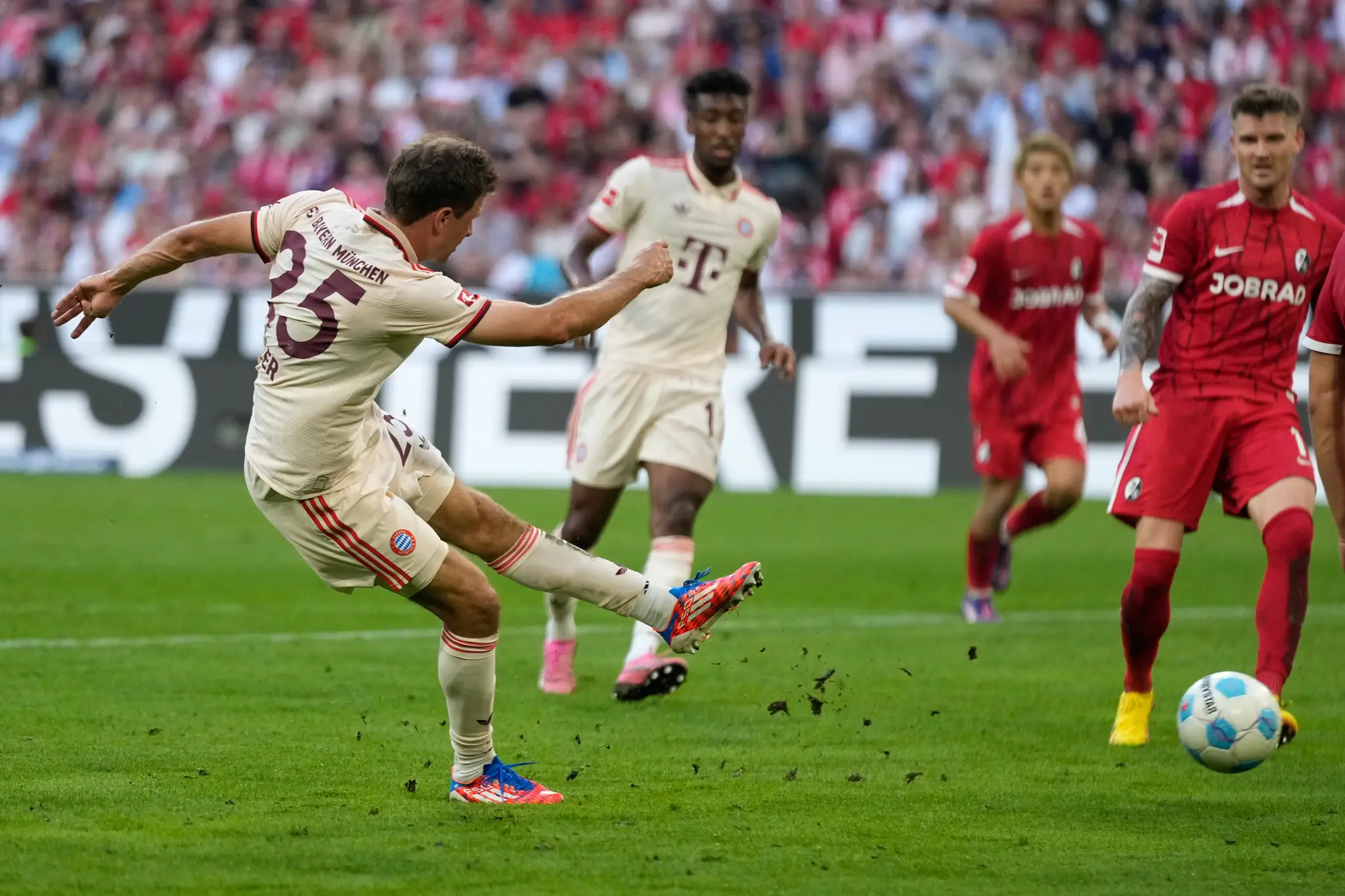 Futbalista Thomas Müller (vľavo) strieľa gól