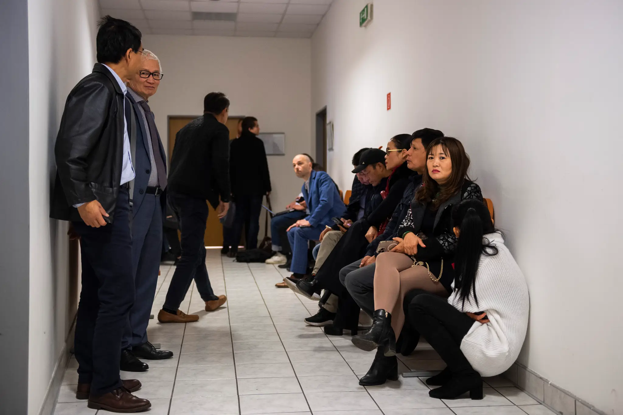 Na snímke ľudia z vietnamskej komunity čakajú na chodbe počas procesu