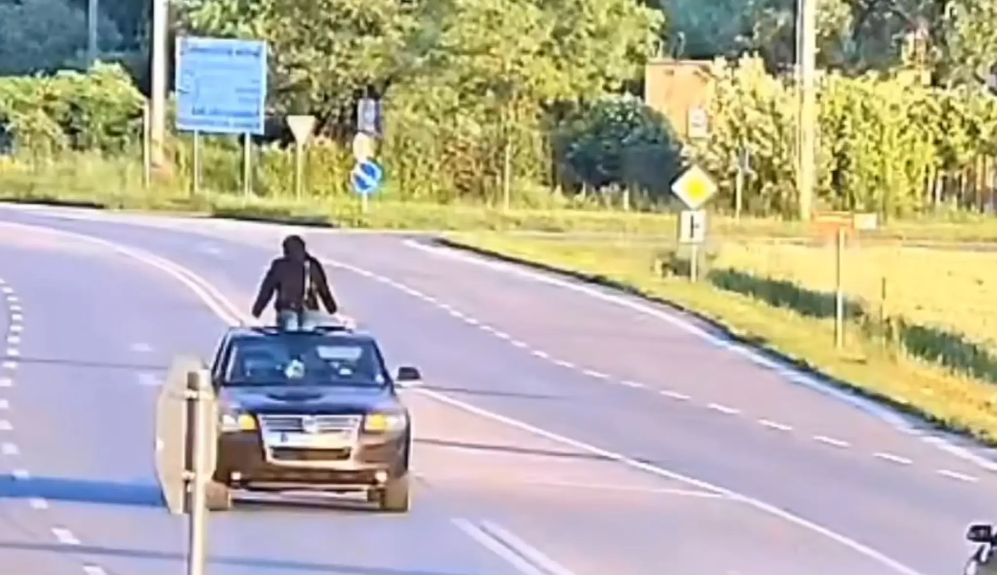 Žena sa vozila na streche auta.