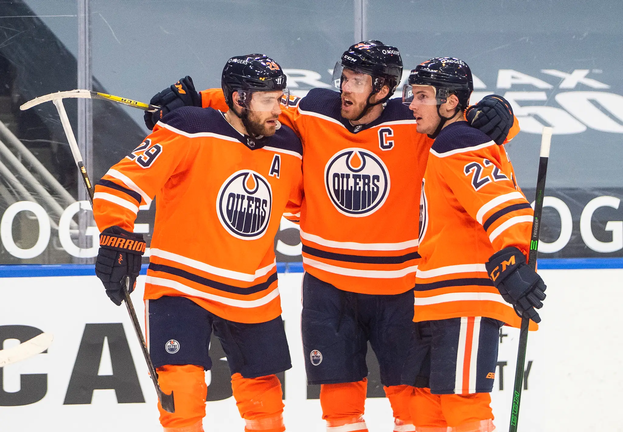 Connor McDavid oslavuje gól so spoluhráčmi Leonom Draisaitlom a Tysonom Barriem.