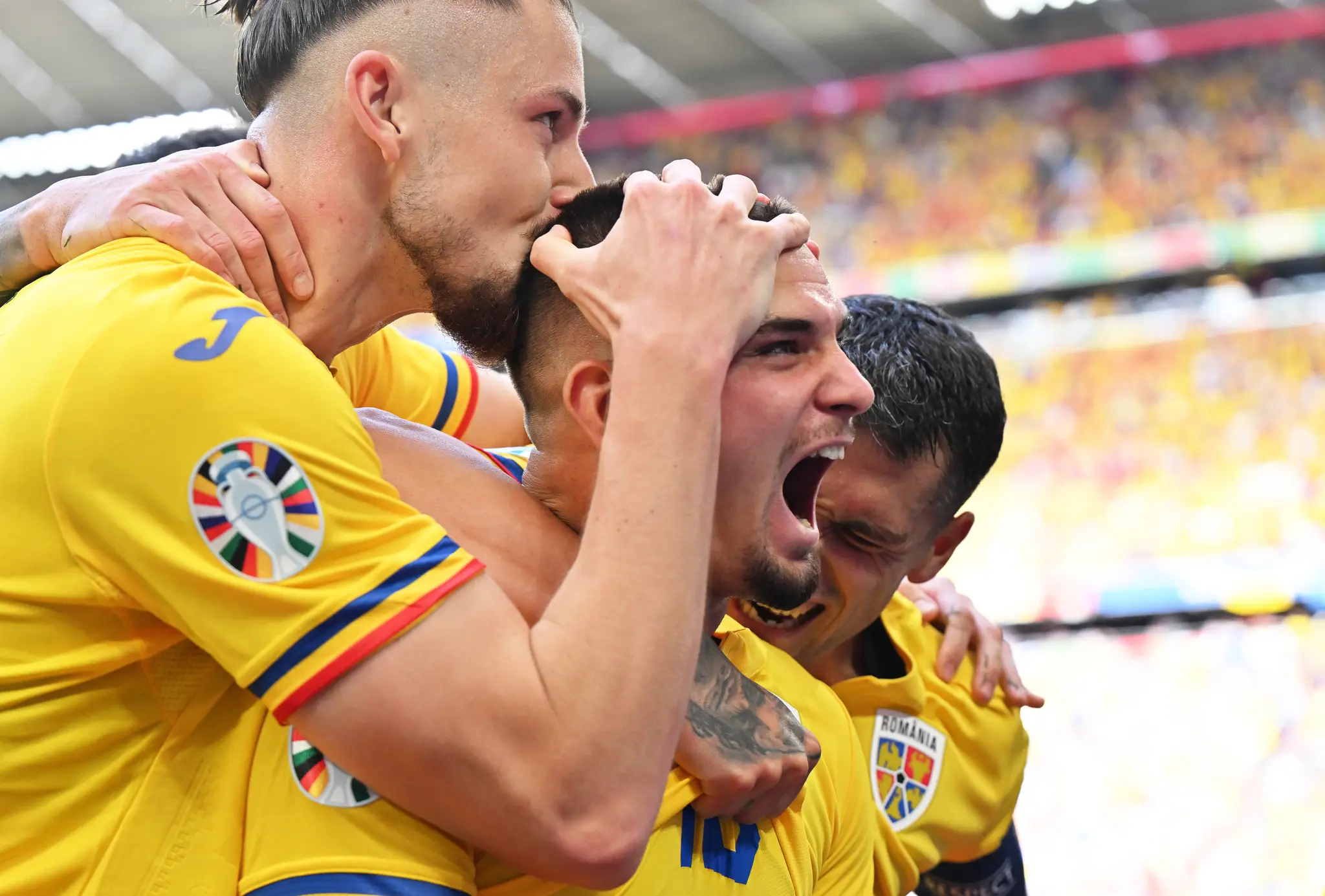 Rumunský futbalista Razvan Marin (uprostred) sa teší so spoluhráčmi.