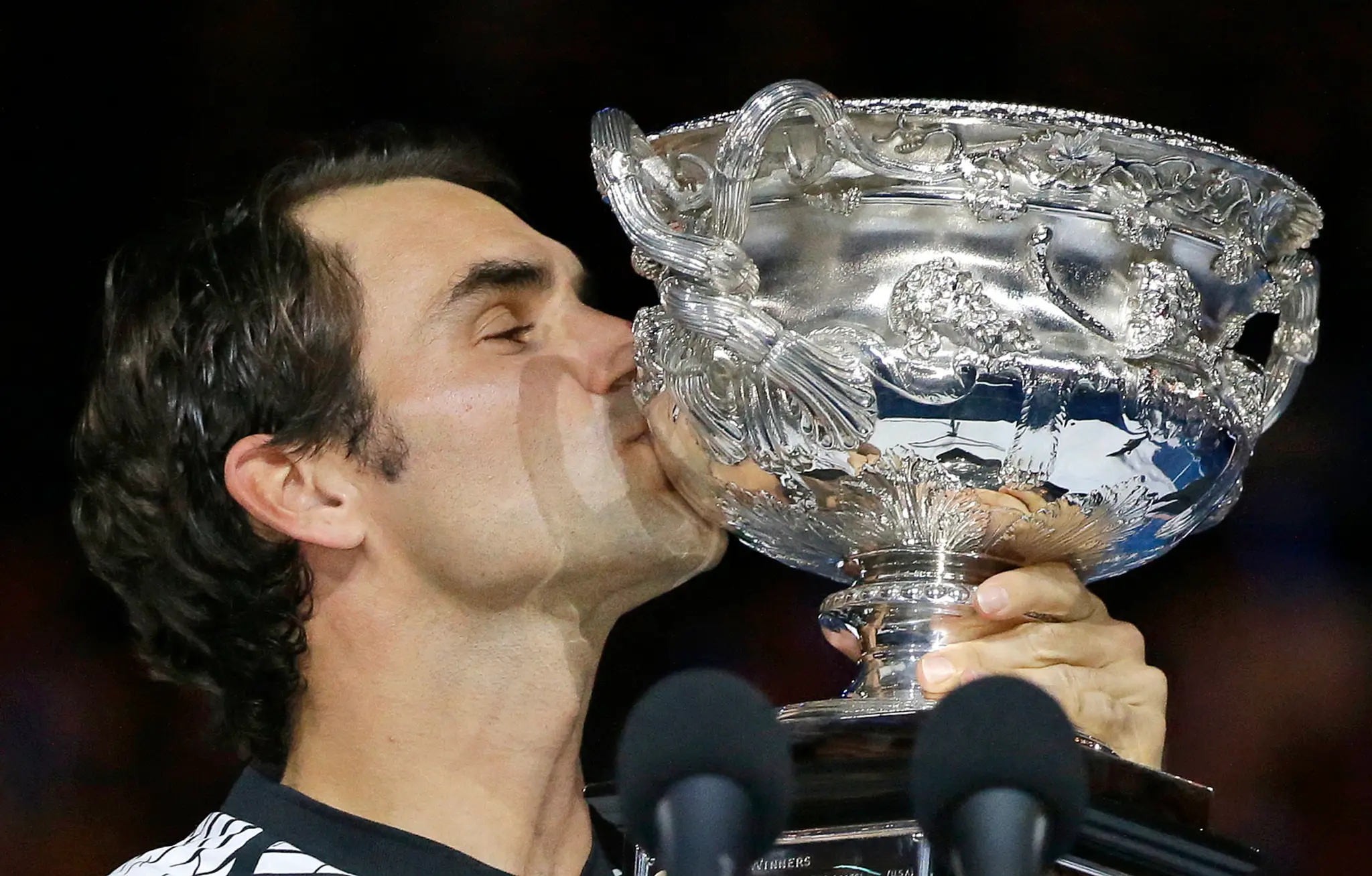 Švajčiarsky tenista Roger Federer bozkáva trofej po výhre nad Španielom Rafaelom Nadalom
