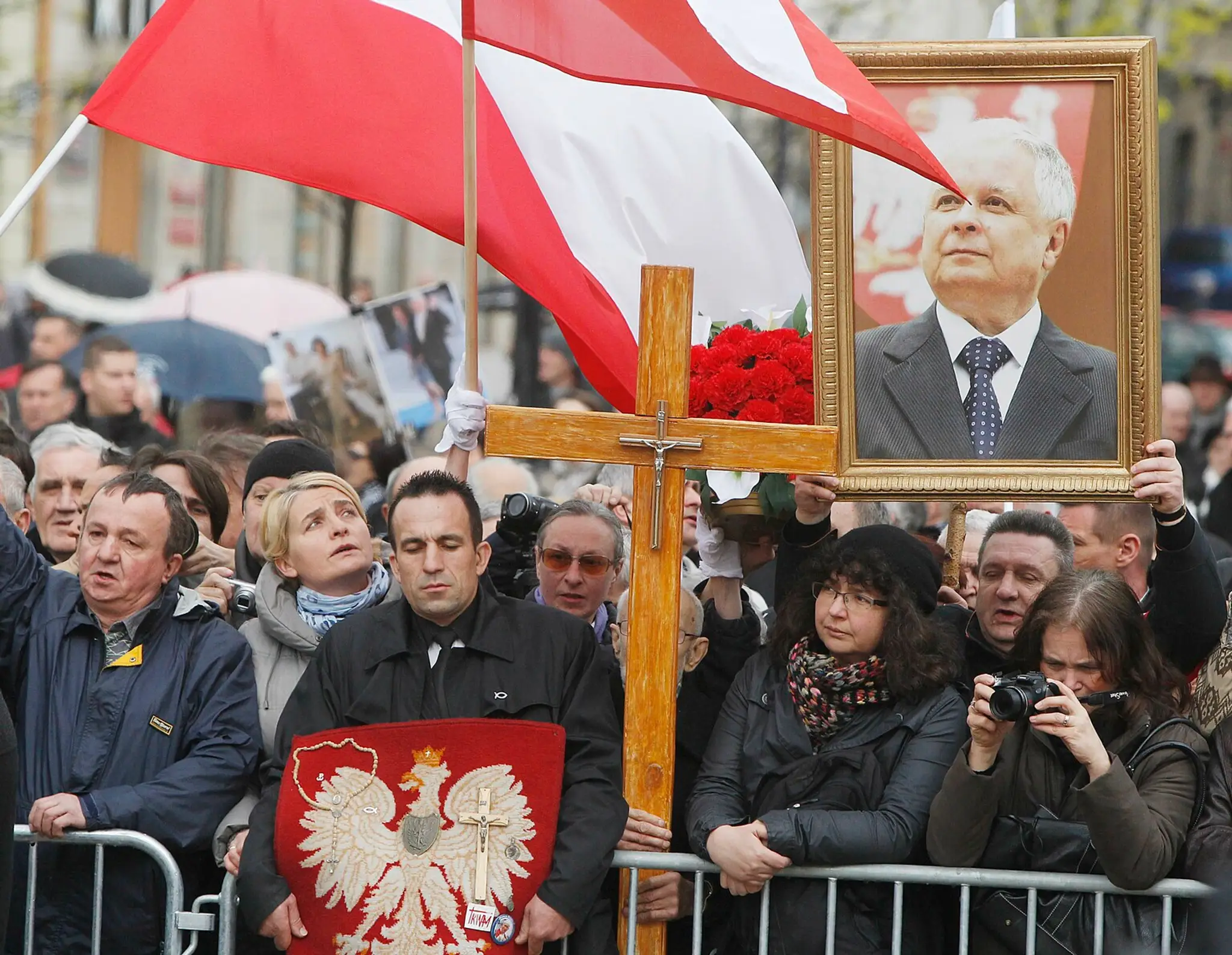 Ľudia držia portrét bývalého poľského prezidenta Lecha Kaczinského.