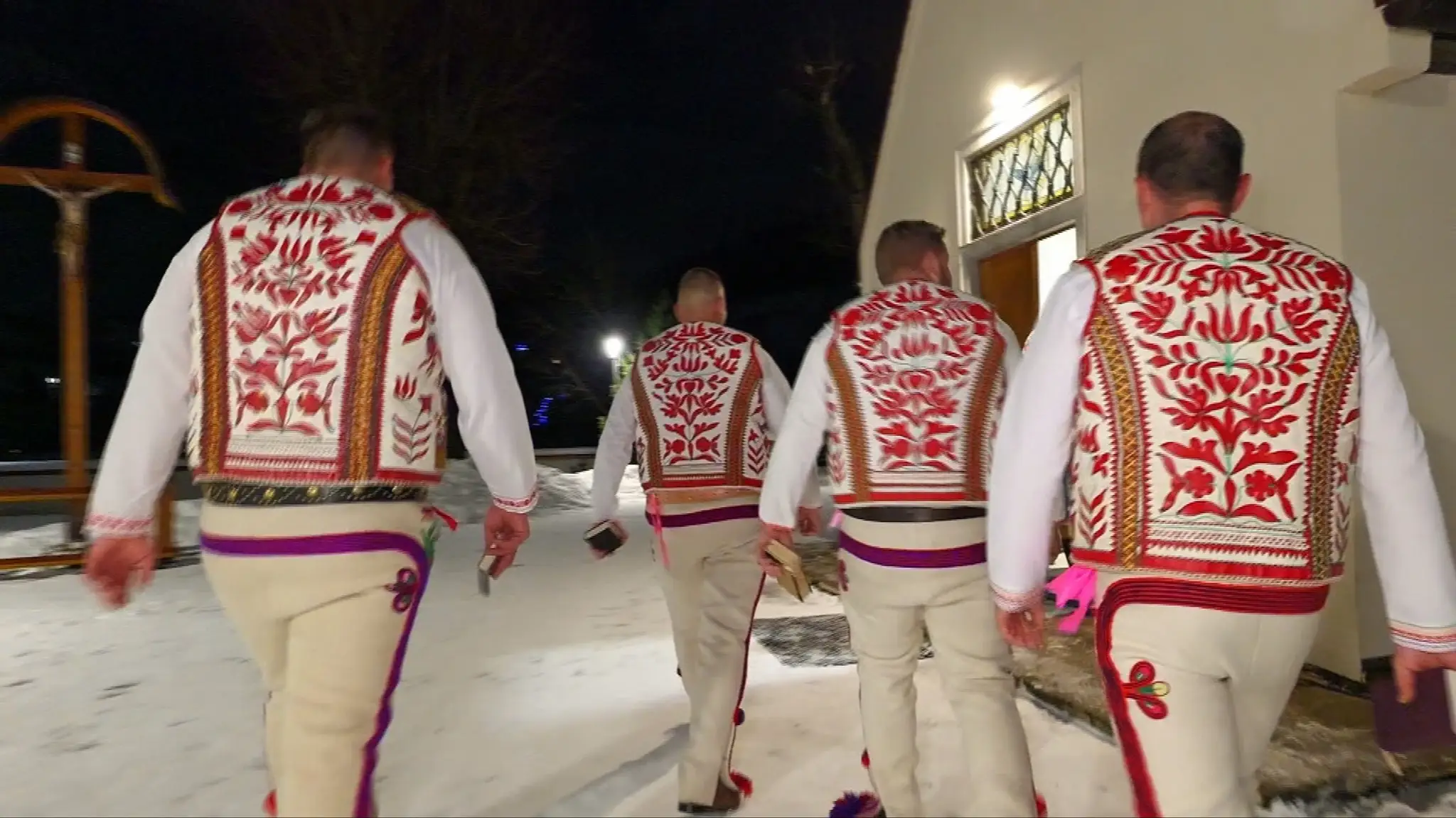 Chlapi v tradičných krojoch vchádzajú do kostola.
