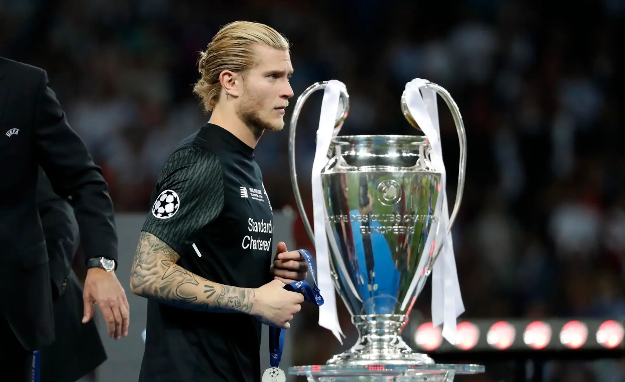 Brankár Liverpoolu Loris Karius kráča pri trofeji pre víťaza Ligy majstrov.